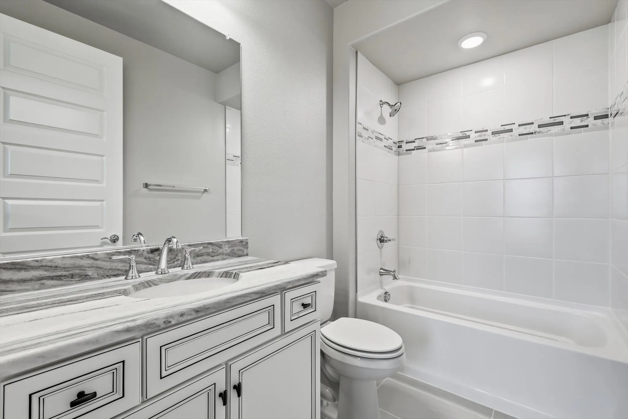Bathroom vanity featuring a double sink with chrome fixtures and a stone-finish countertop