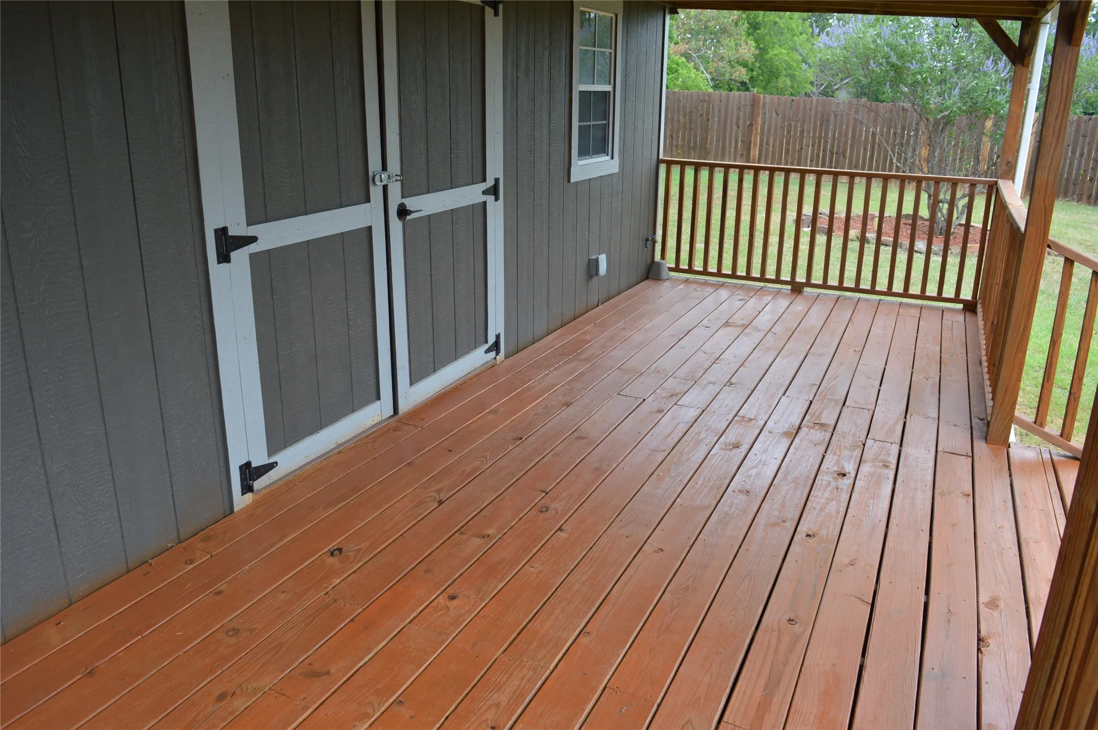 Expansive outdoor deck with natural wood flooring and coordinating wood railings