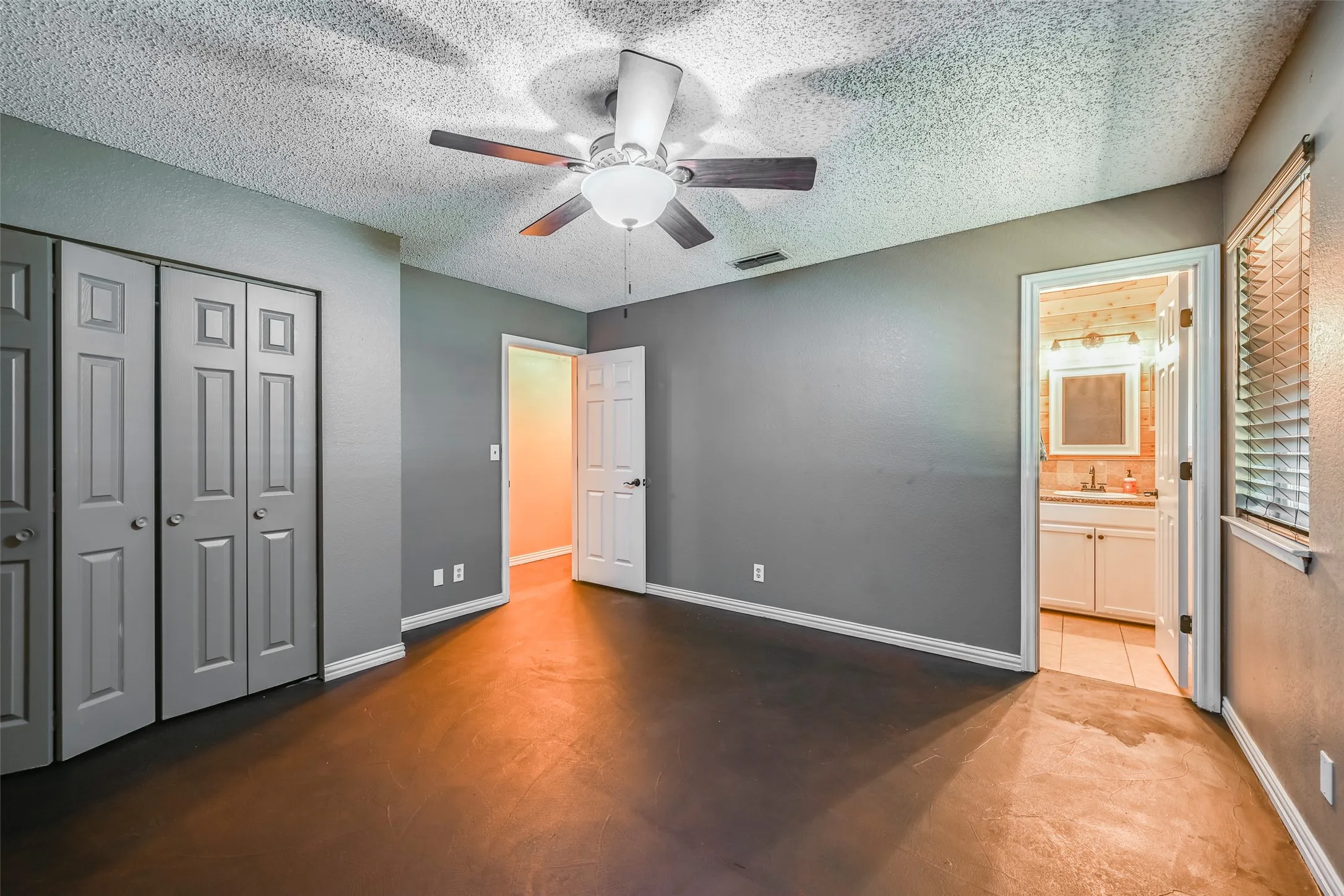 Master Bedroom featuring wood-finish flooring, neutral gray walls, a ceiling fan with light fixture, and bifold closet doors