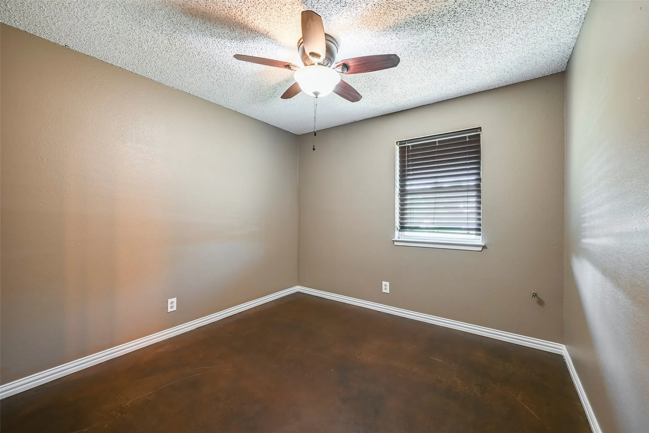 Interior room featuring wood-finish flooring, a ceiling fan with integrated lighting, and a single window with blinds