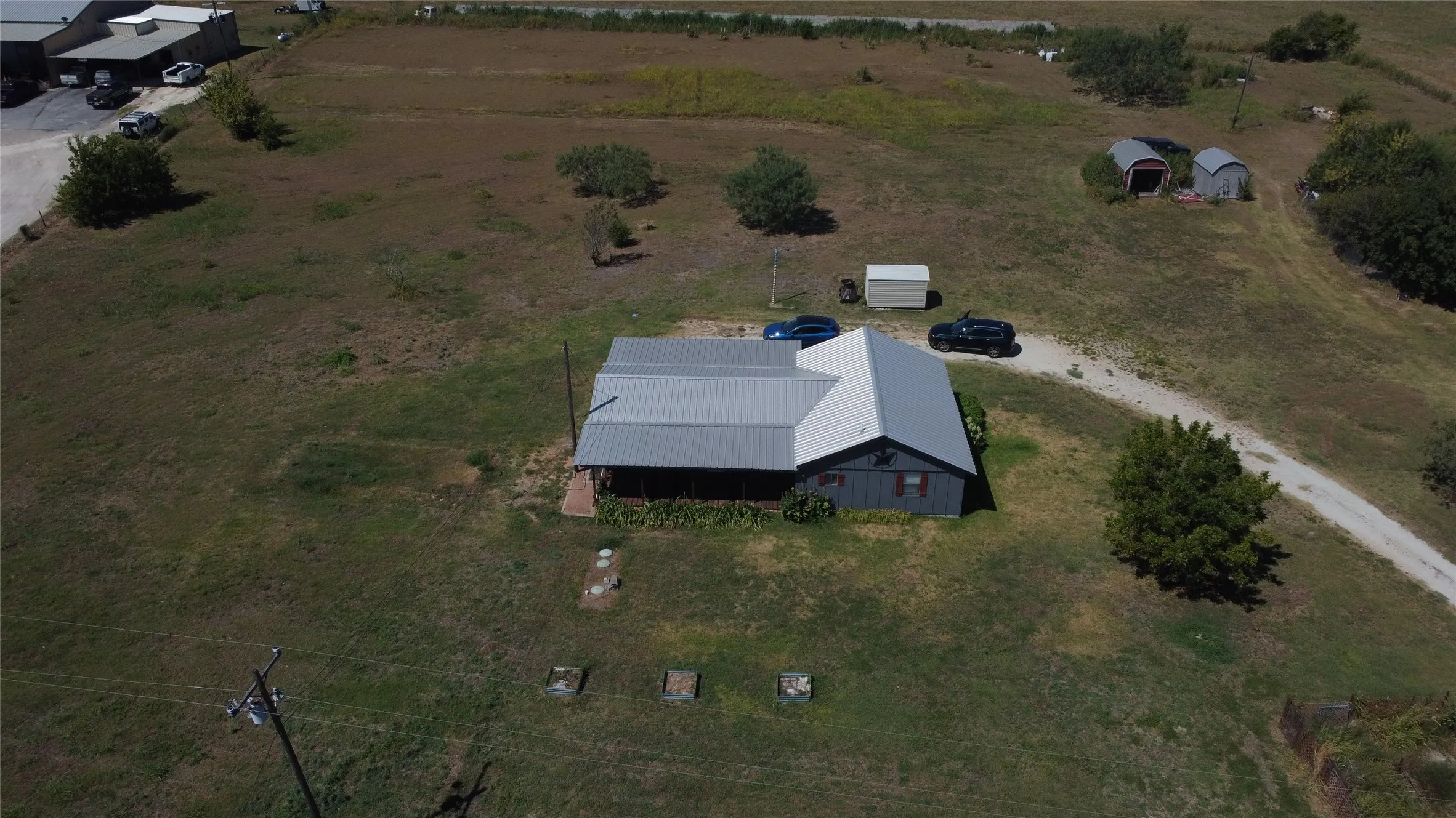 Expansive lot featuring a single-story residence with a metal roof and a covered front porch