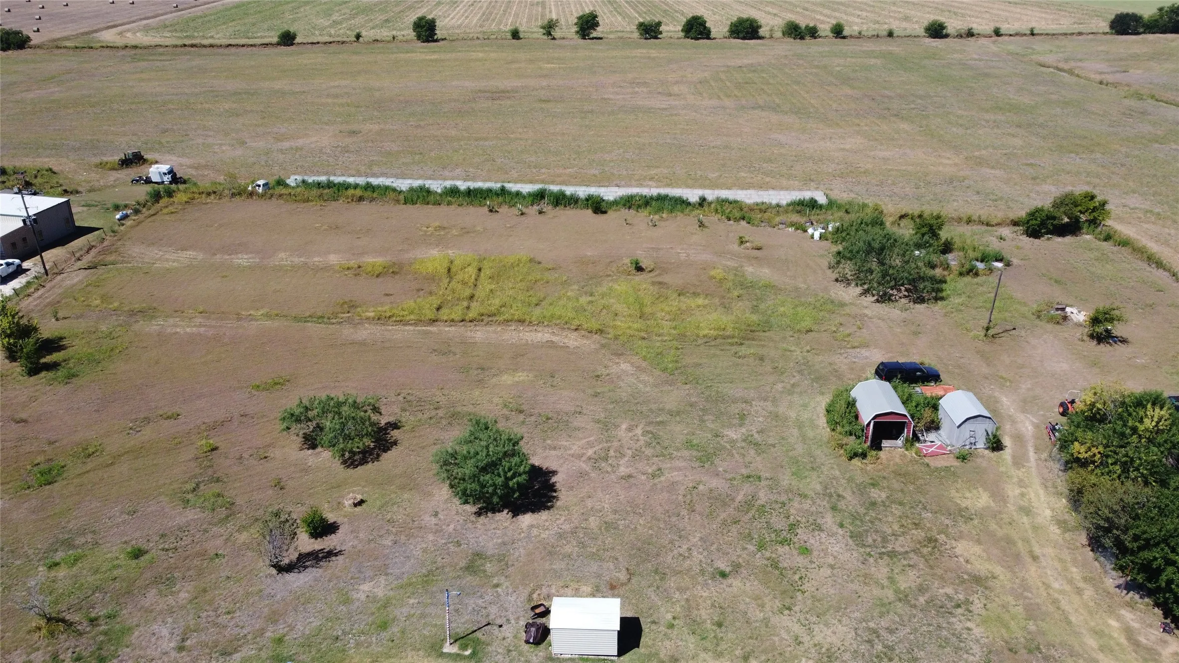 Expansive rural property featuring multiple outbuildings and open land