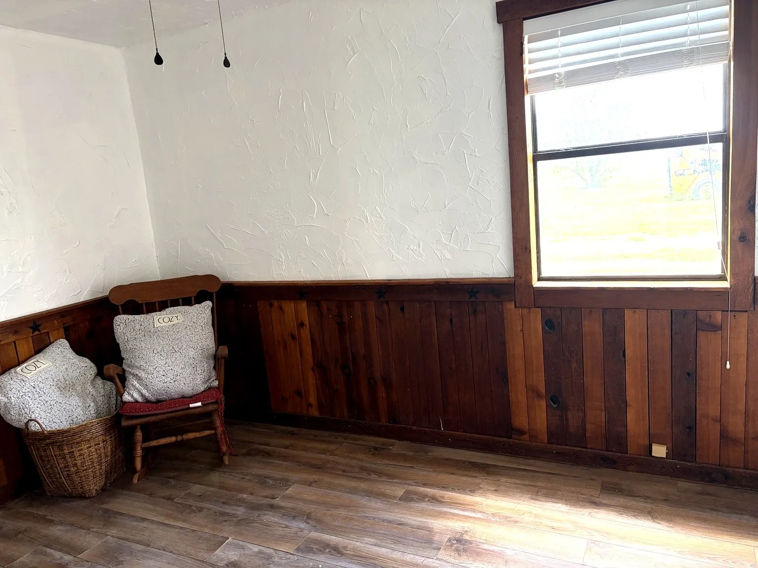 Warm wood-finish flooring complements the natural wood wainscoting and window trim