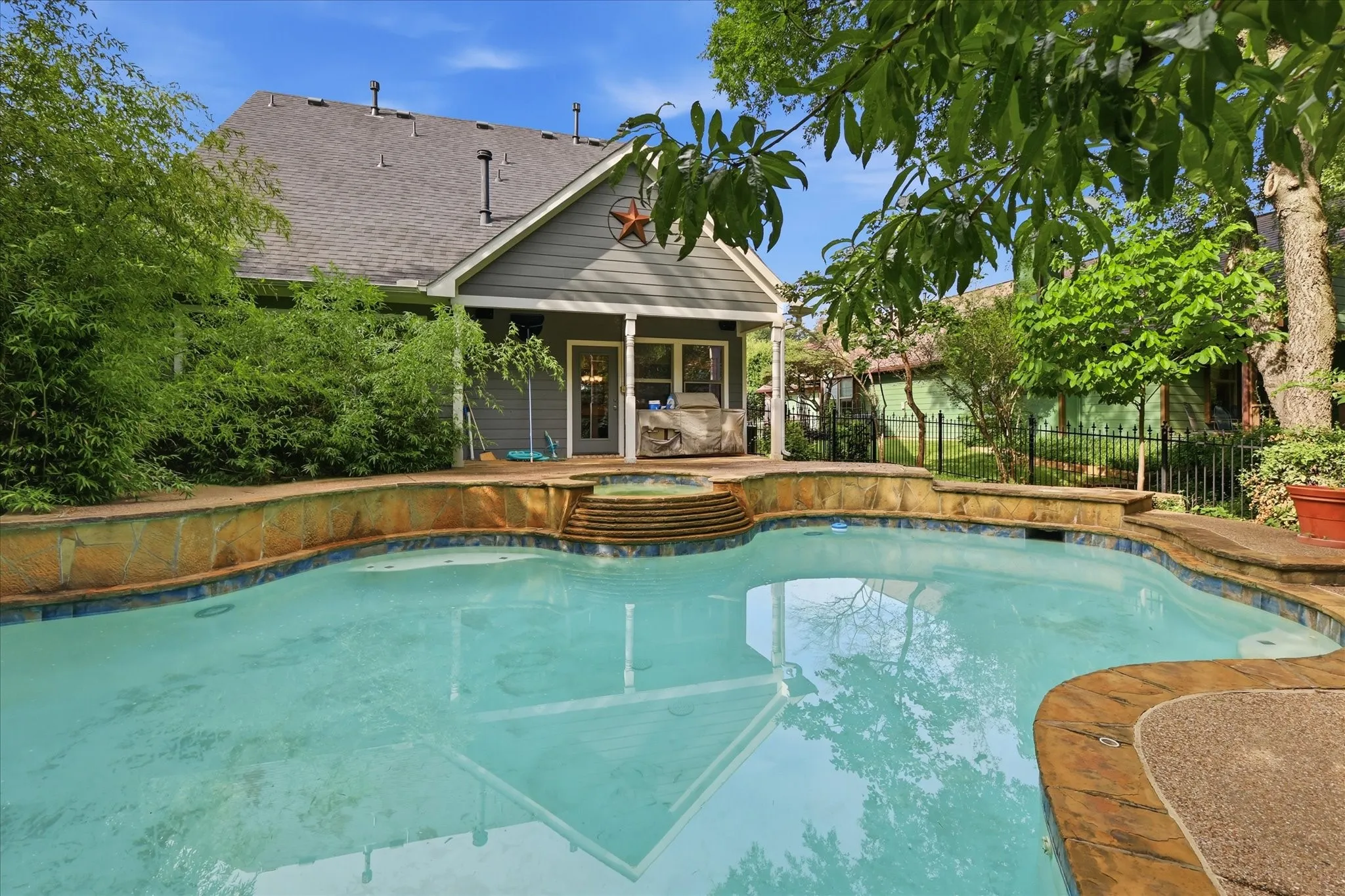 Heated inground pool with integrated spa and stone coping