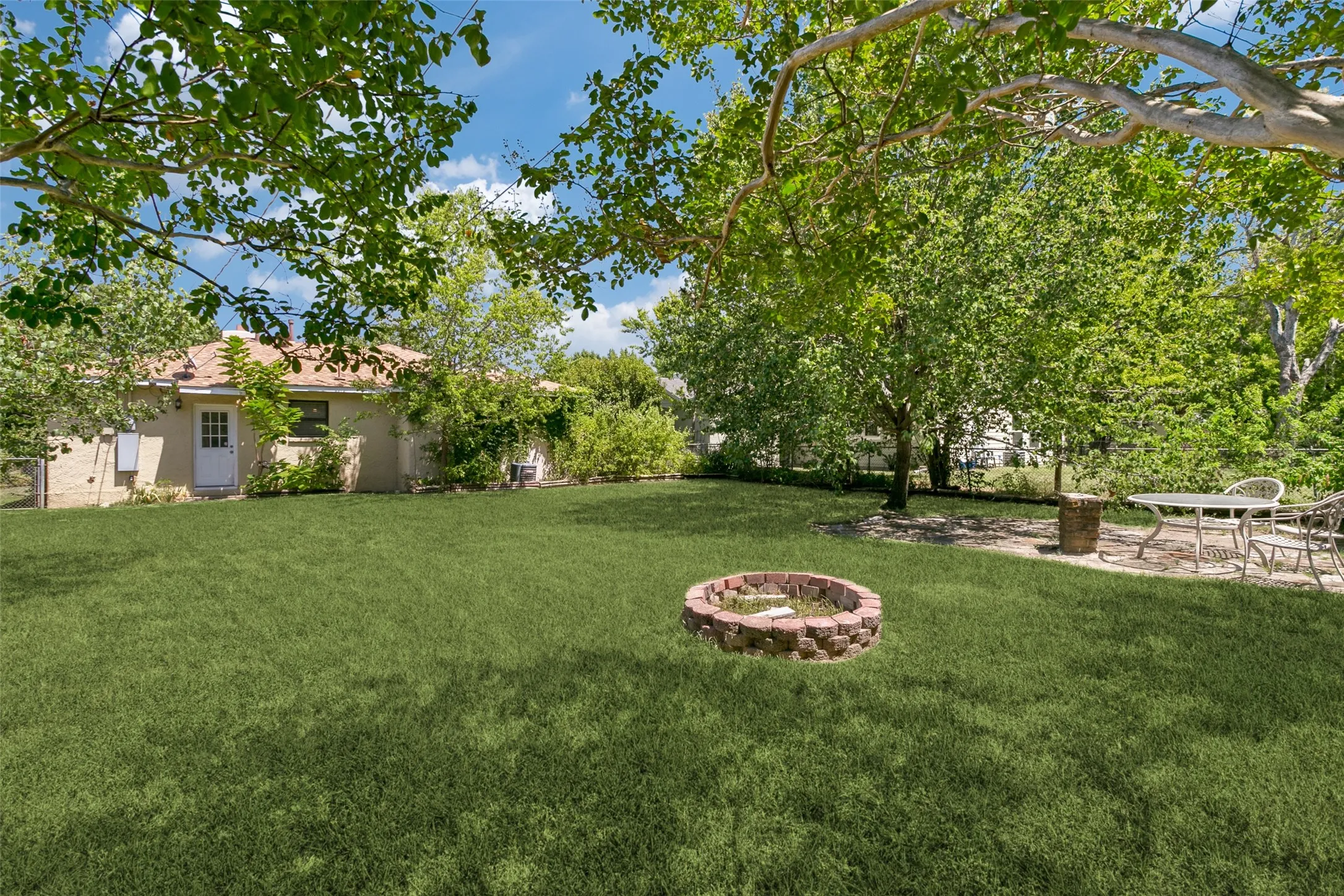 large backyard with firepit and shed