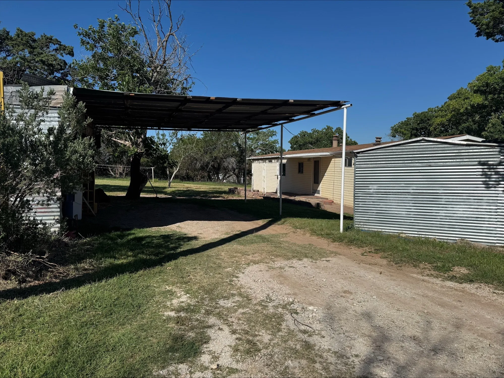 4 or 5 car carport and-or storage. Back porch in background.