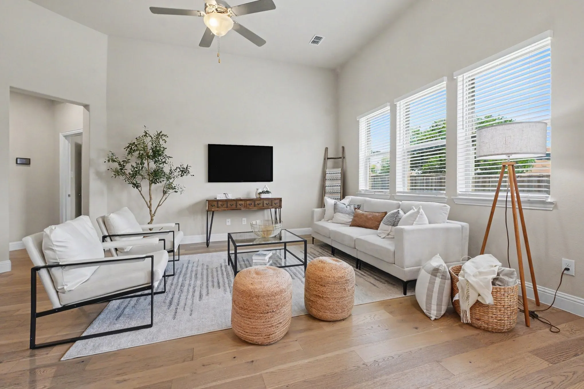 Hardwood-finish flooring, vaulted ceilings, and a ceiling fan with integrated lighting