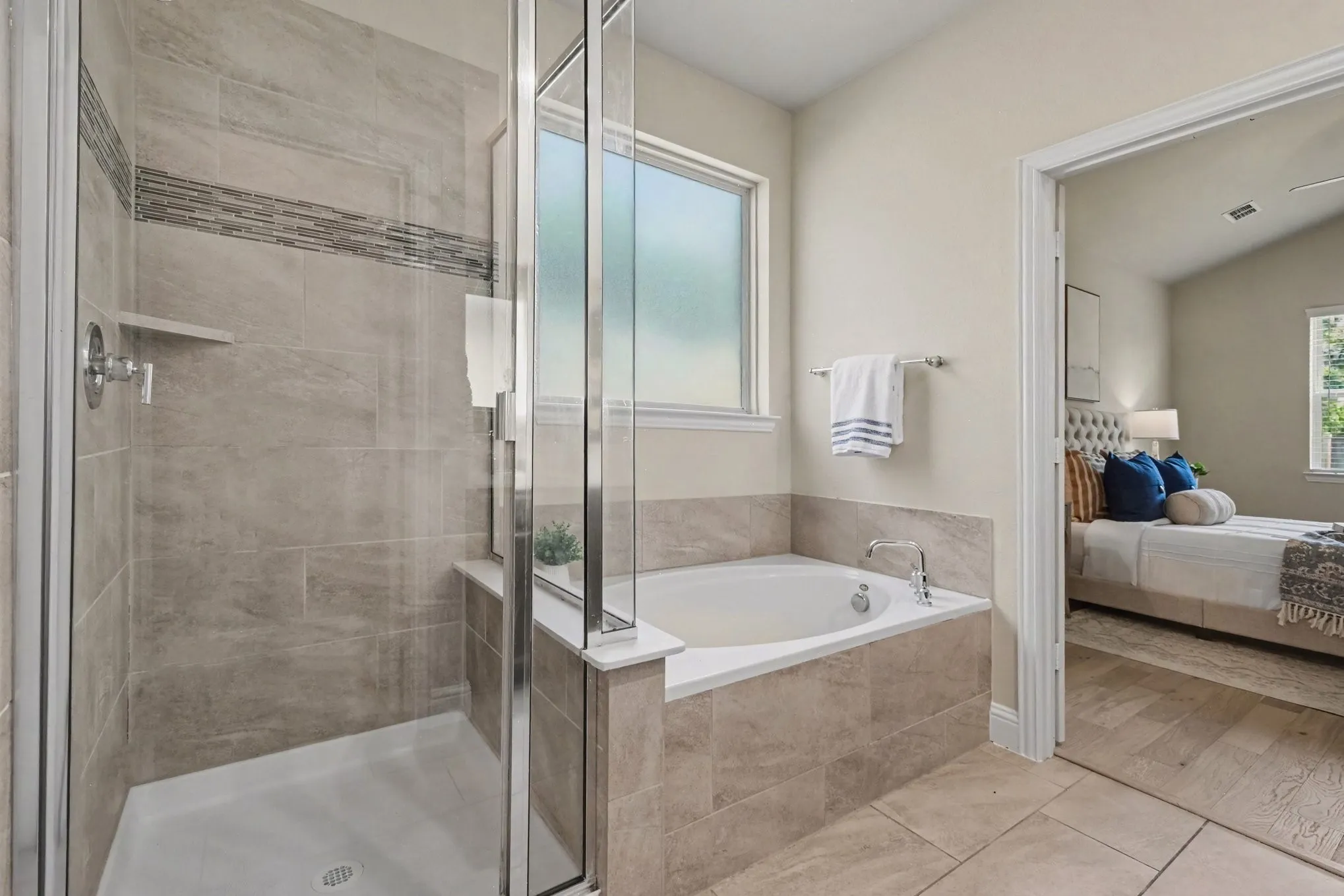 Walk-in shower with glass enclosure, tiled walls, and an integrated shelf