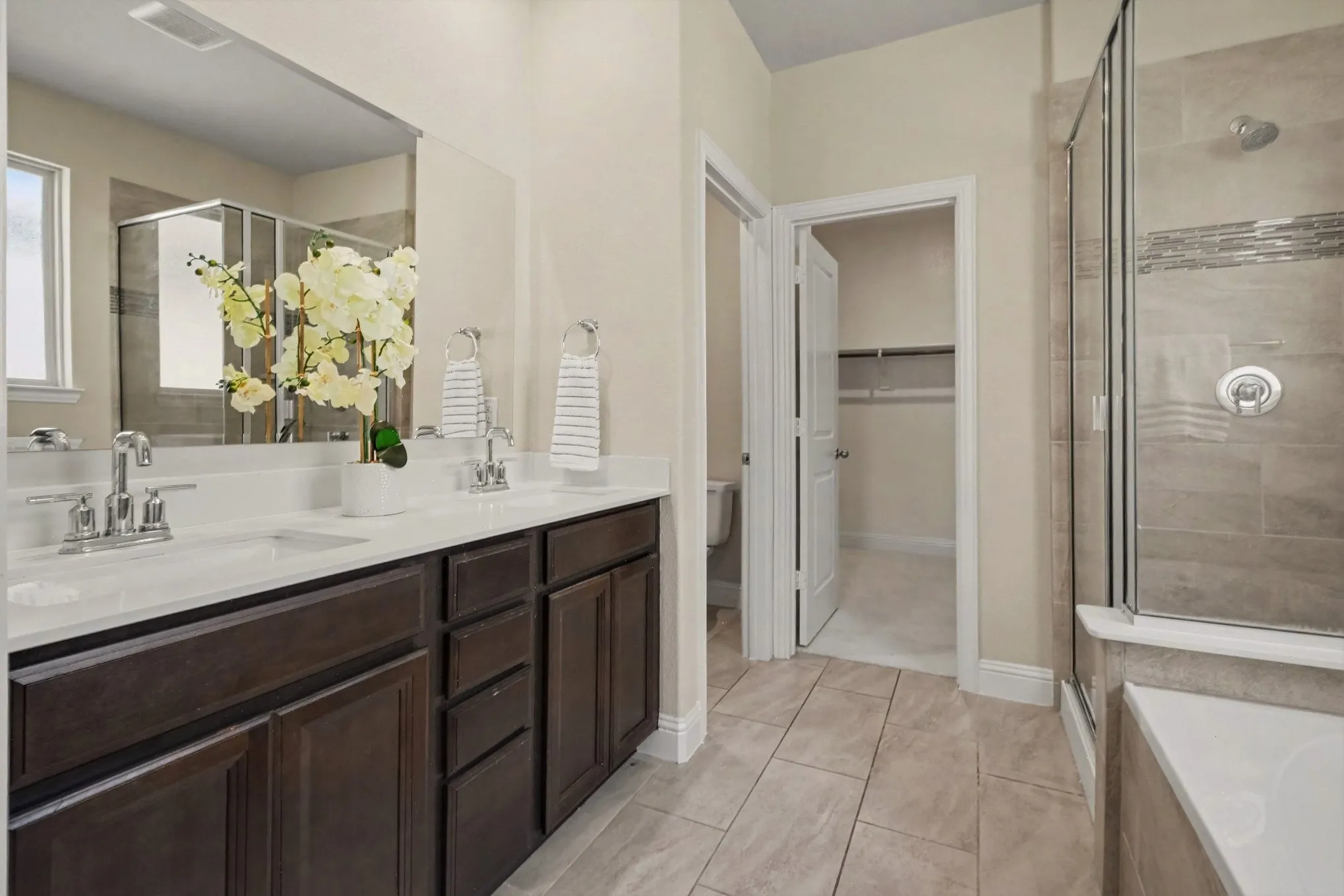 Dual vanity with undermount sinks, chrome fixtures, and dark wood-finish cabinetry