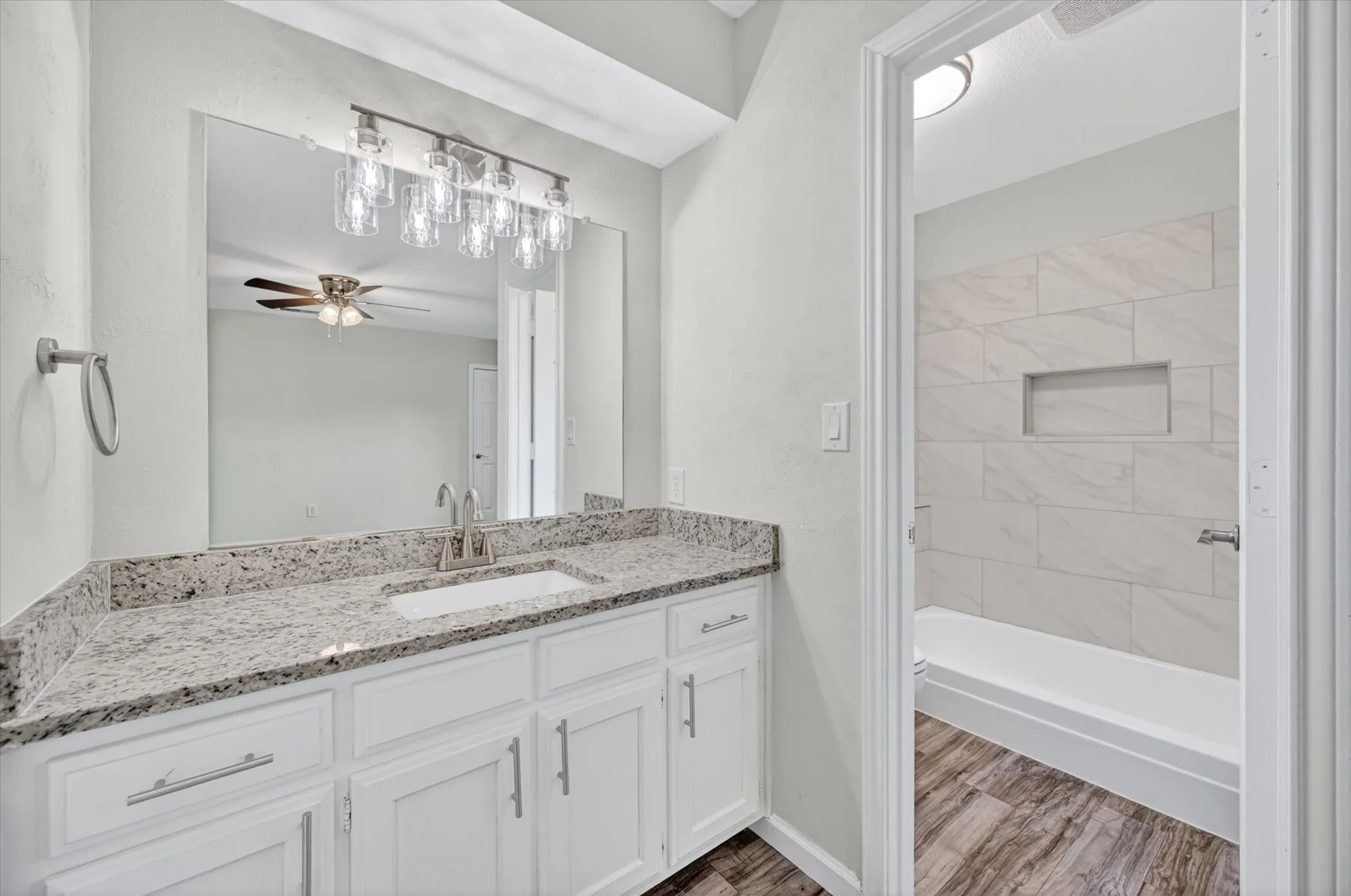 Vanity featuring a stone countertop, an undermount sink, and a brushed nickel faucet