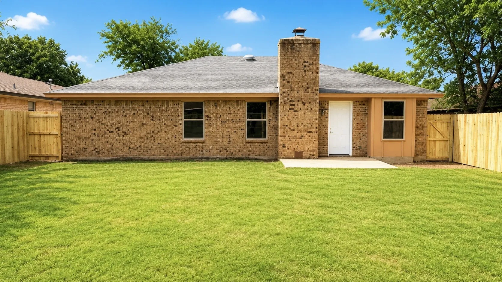 Expansive green lawn with a newly installed wood privacy fence