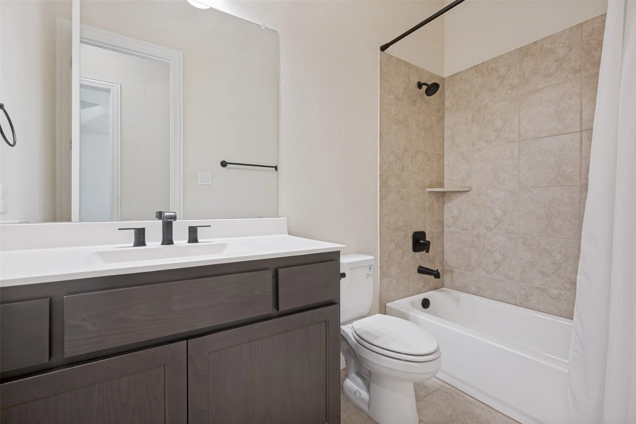 Bathroom featuring a dark wood-finish vanity with a white countertop and rectangular undermount sink