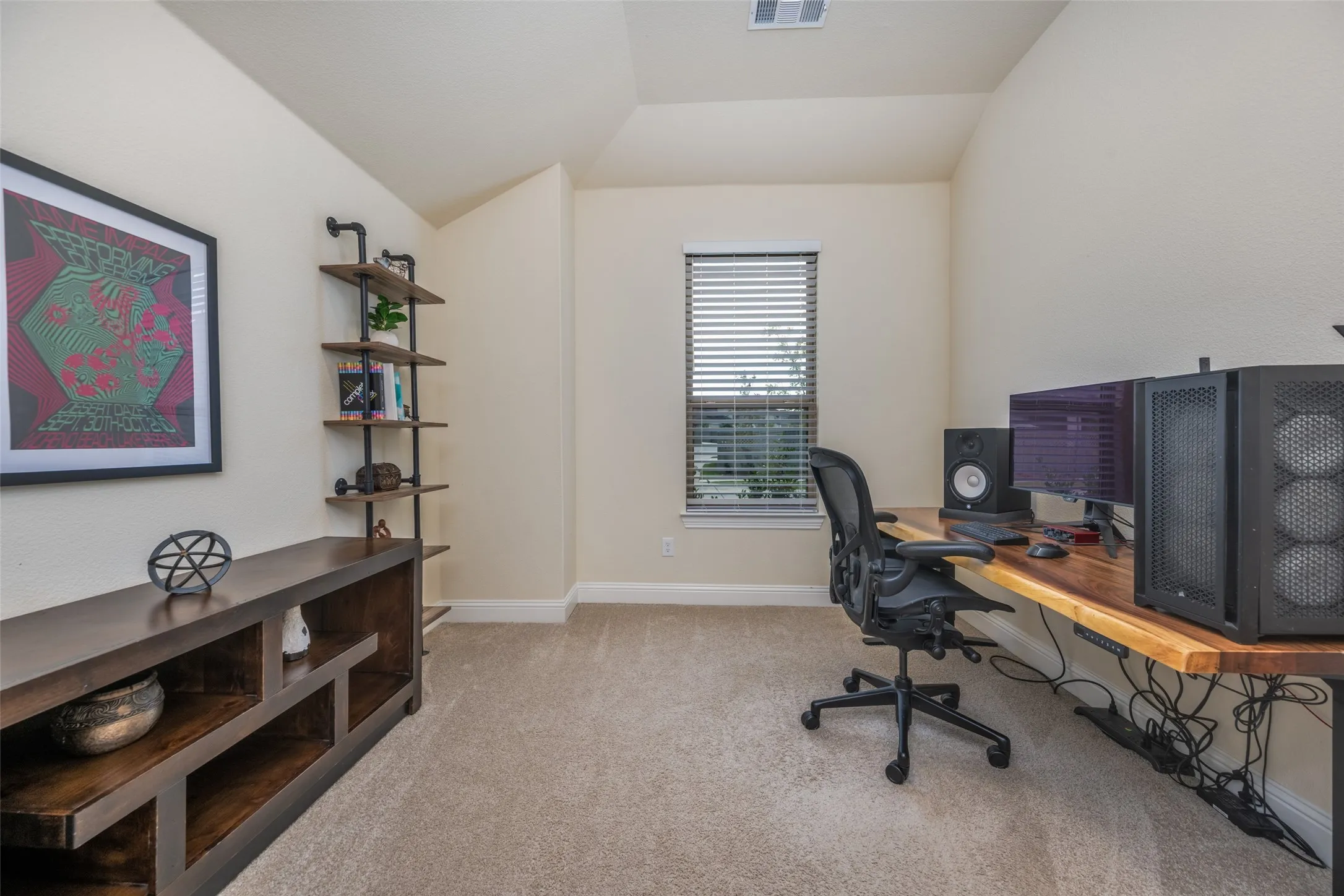 Versatile room featuring light-colored walls, neutral carpet flooring, and a large window with horizontal blinds