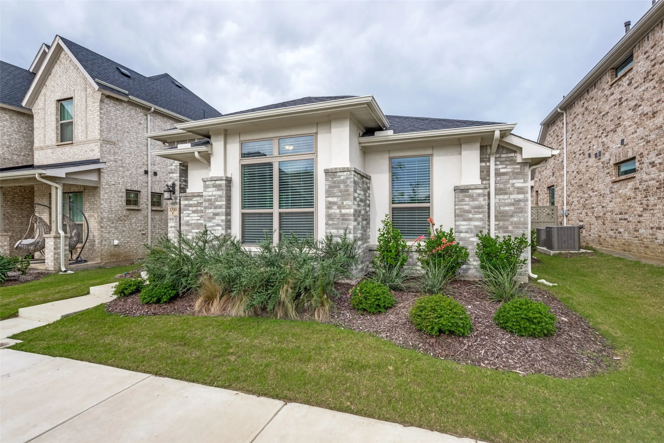 Contemporary exterior featuring a combination of stucco and variegated stone masonry