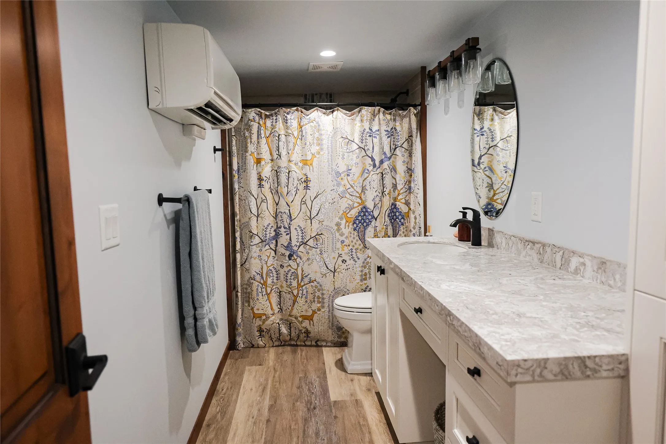Guest bathroom with  shower, a quartz vanity with a makeup counter, plenty of storage and mini split climate control.