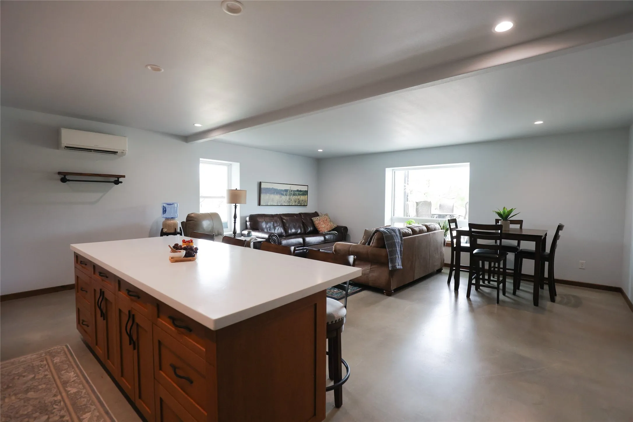 Accessible main floor living area with an open floor plan, smooth sealed concrete floors and a large quartz island. Bright picture windows and a dining area make it a comfortable, single level suite within this Texas ranch home.
