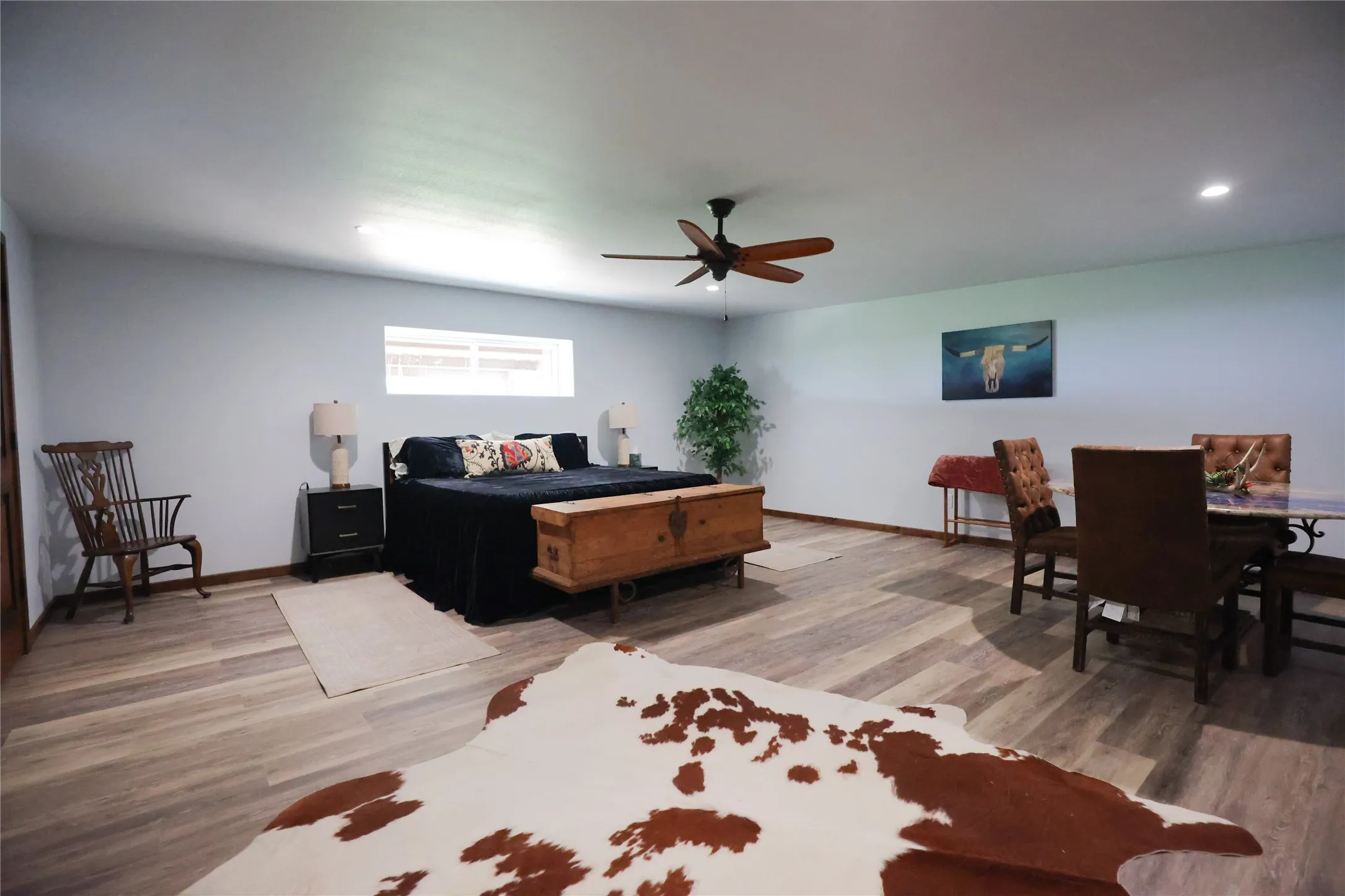 Oversized bedroom with room for a king bed and a separate sitting or dining area. Luxury vinyl plank floors, a ceiling fan and a window for natural light make it ideal as a guest suite or primary retreat.