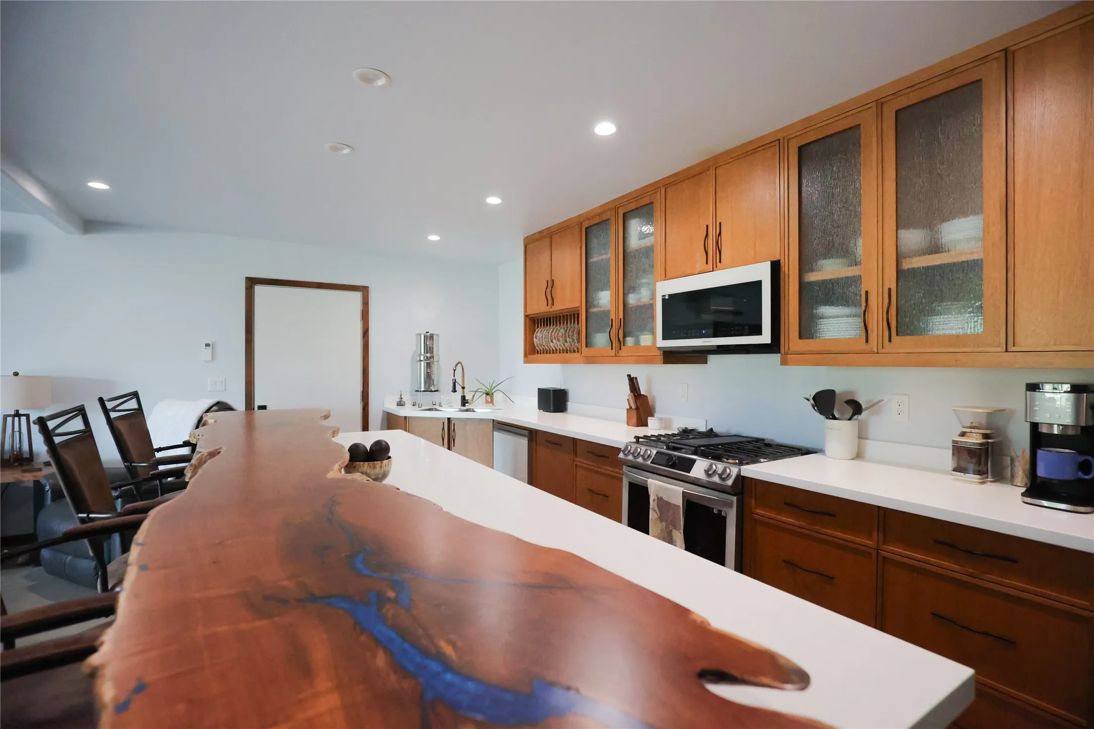 Quartz kitchen island, da gas range, glass front cabinets and seating for family and guests.