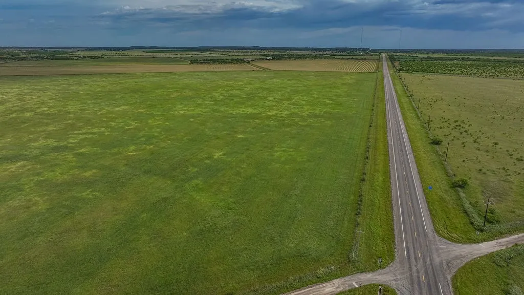 Long stretch of paved highway frontage along green pasture and hay fields. The convenient access works well for a working cattle ranch, horse property or future use.