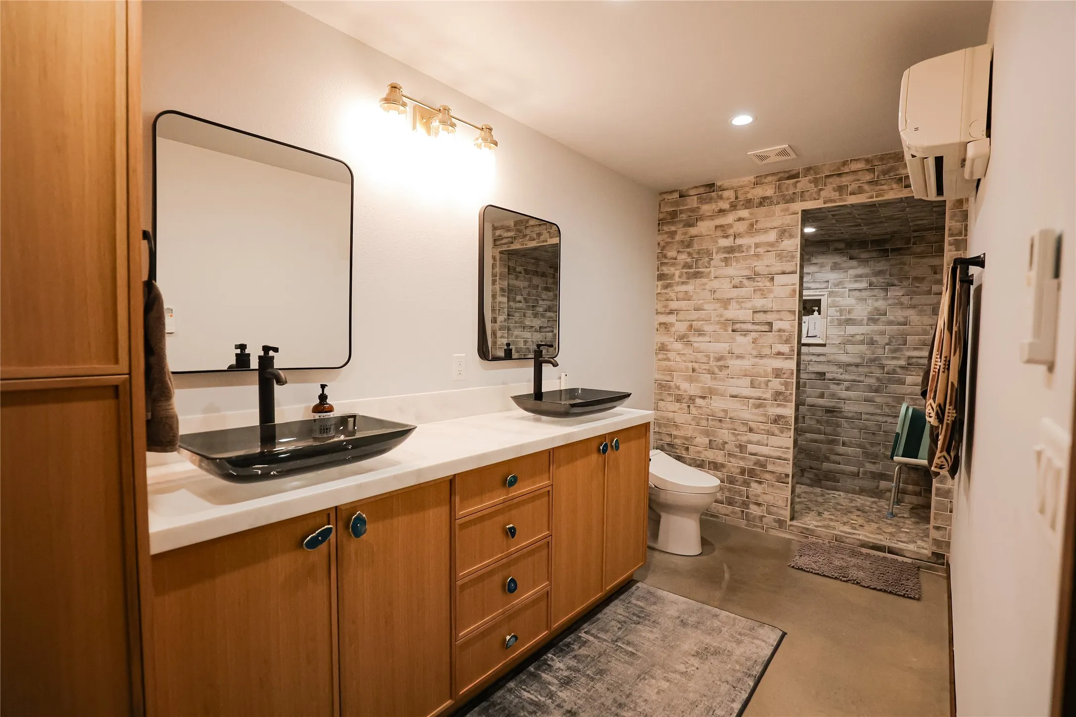 Bathroom with dual vessel sinks, quartz counters, a bidet toilet and a large walk in tiled shower.