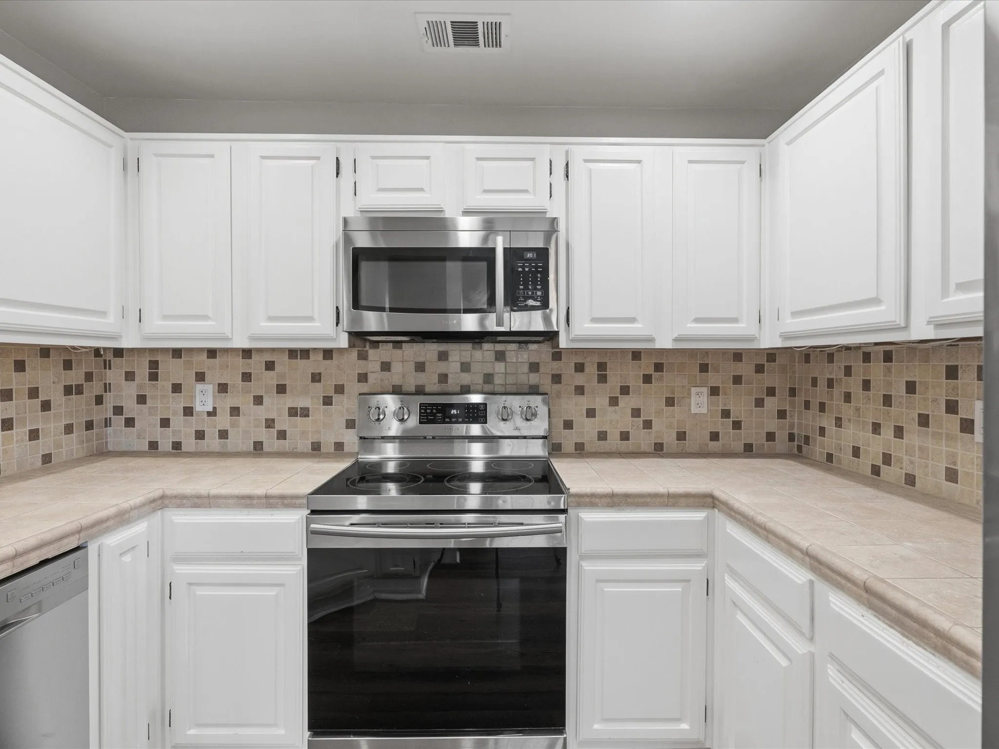 Kitchen featuring white cabinetry and stainless steel appliances