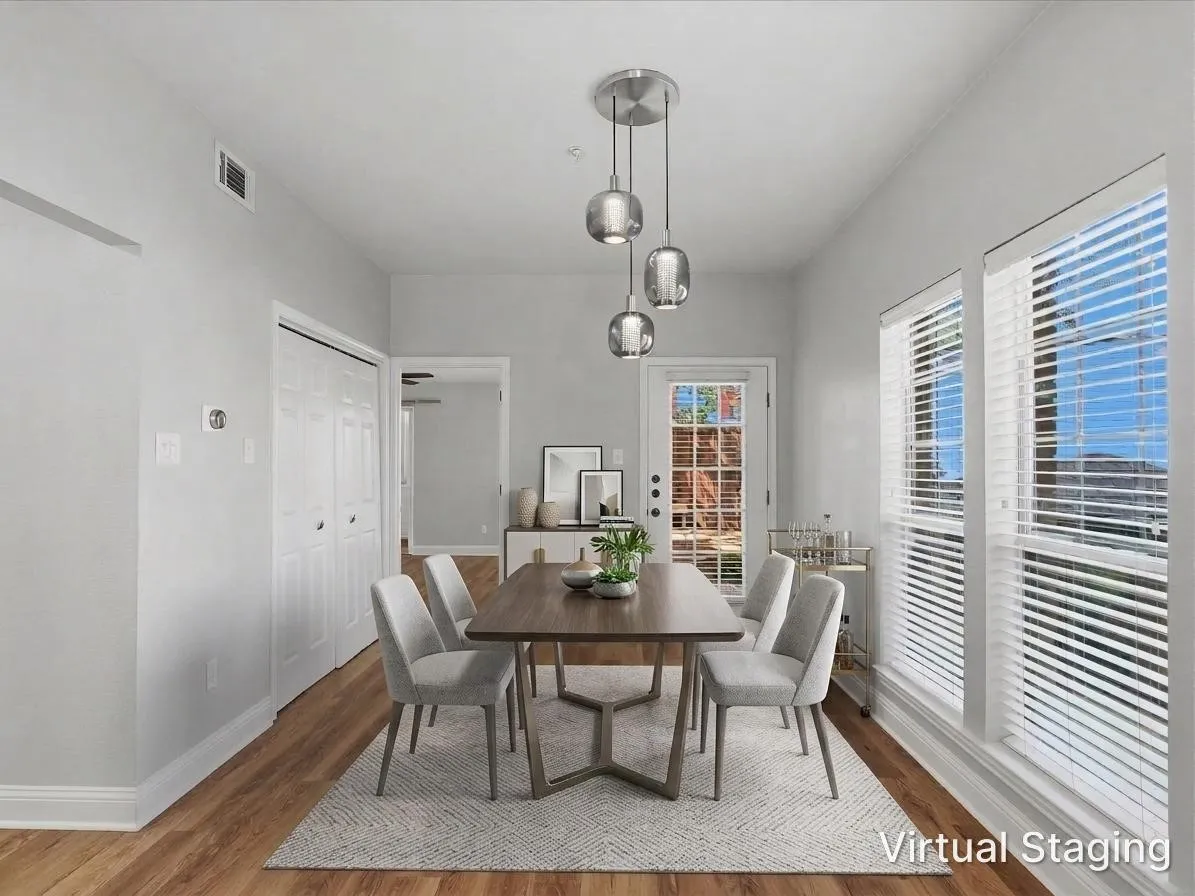 Wood-finish flooring, multiple windows with blinds, and a glass-paned exterior door