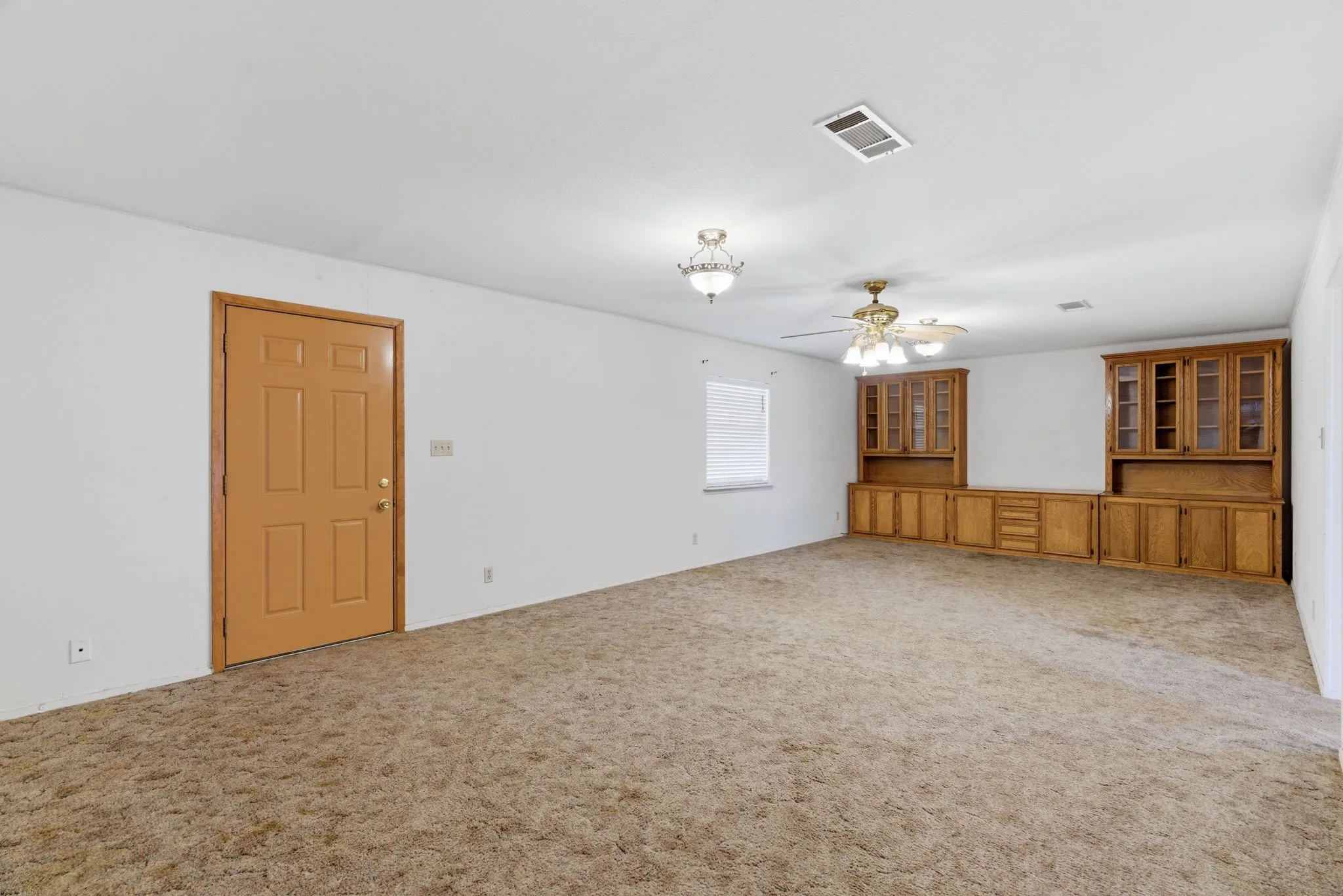Spacious living area featuring built-in cabinetry