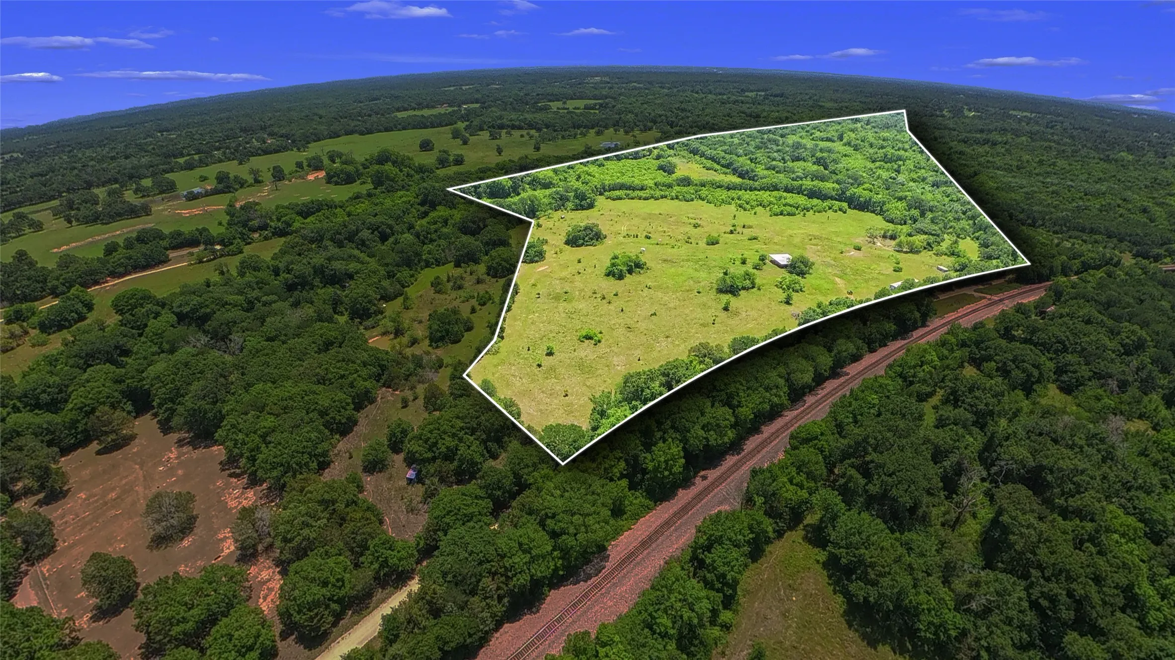Expansive parcel featuring a mix of open fields and mature tree coverage