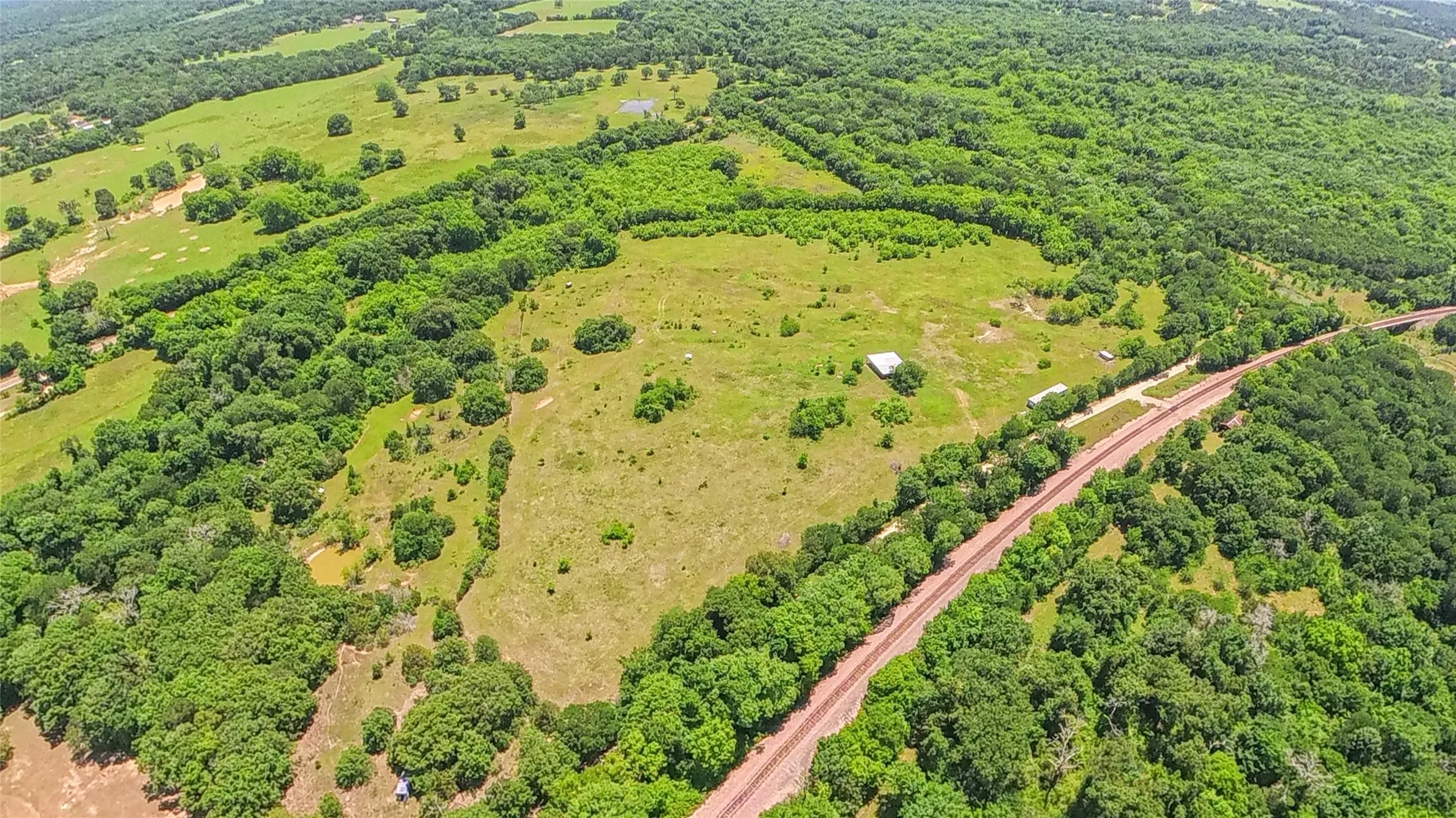 Expansive acreage featuring natural green spaces, wooded areas, and open fields