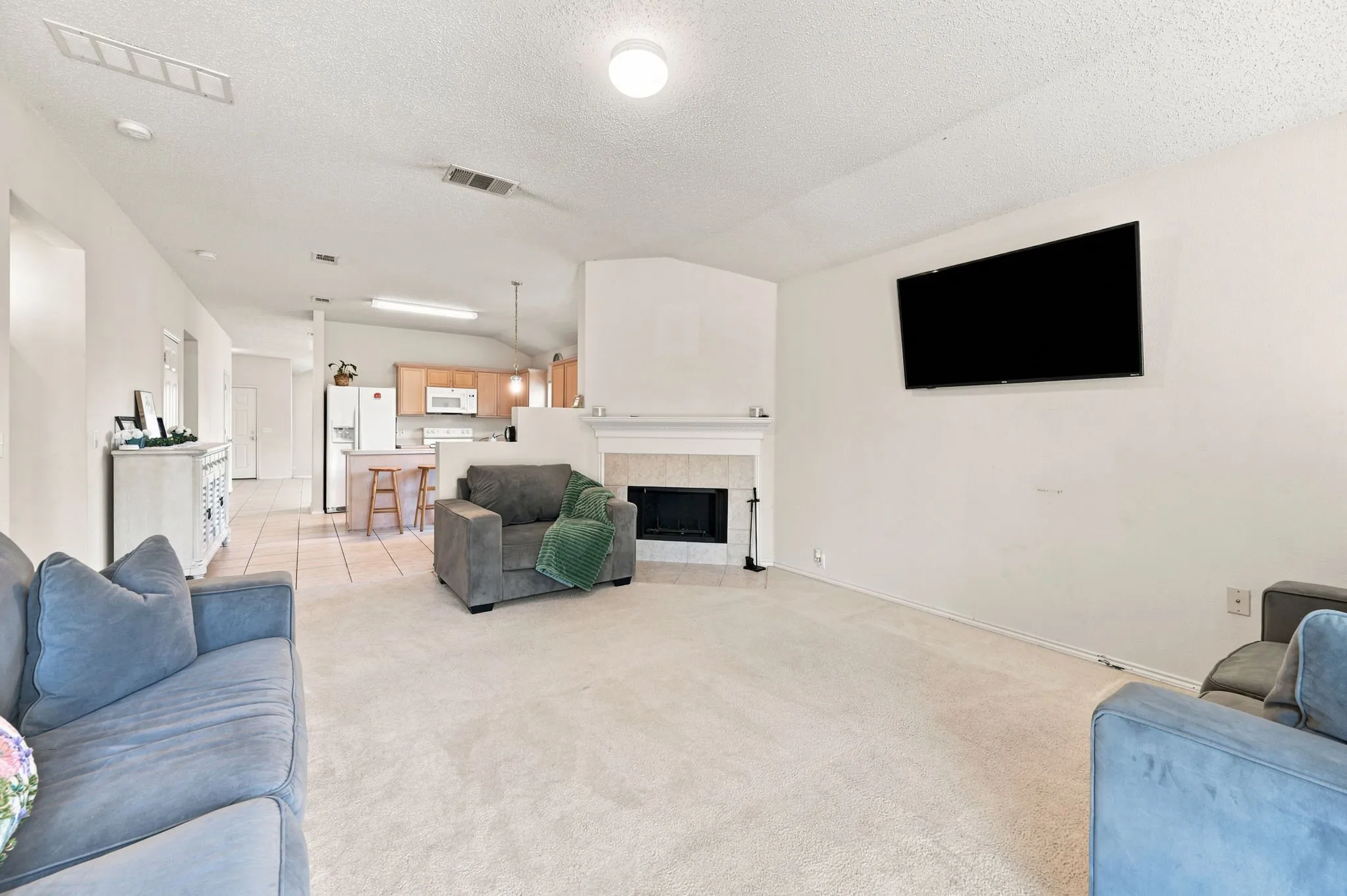 Check out this family living area with room for furnishings and lovely tiled fireplace with mantel.