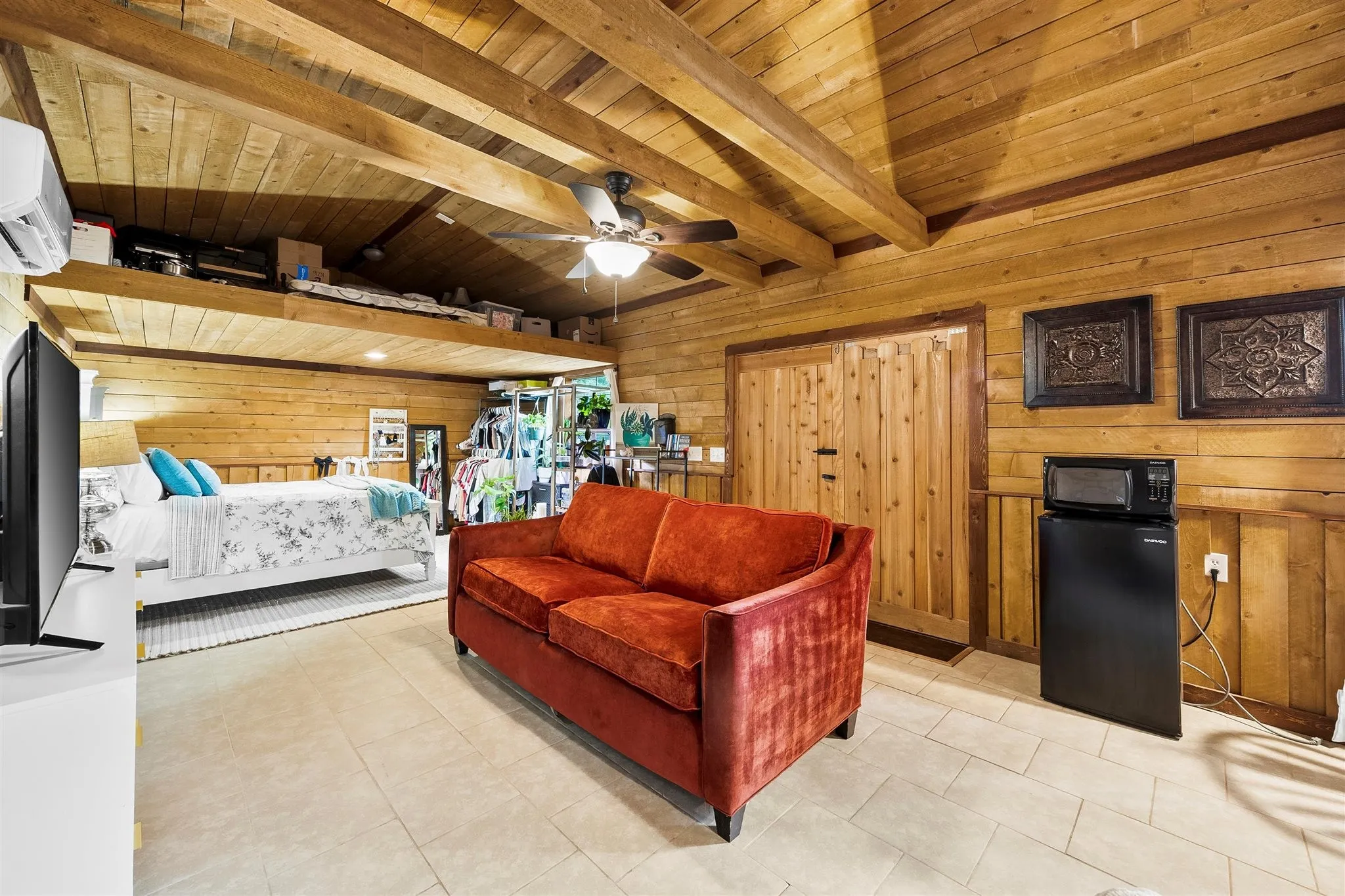 Rustic living space featuring extensive wood paneling and exposed wood beams