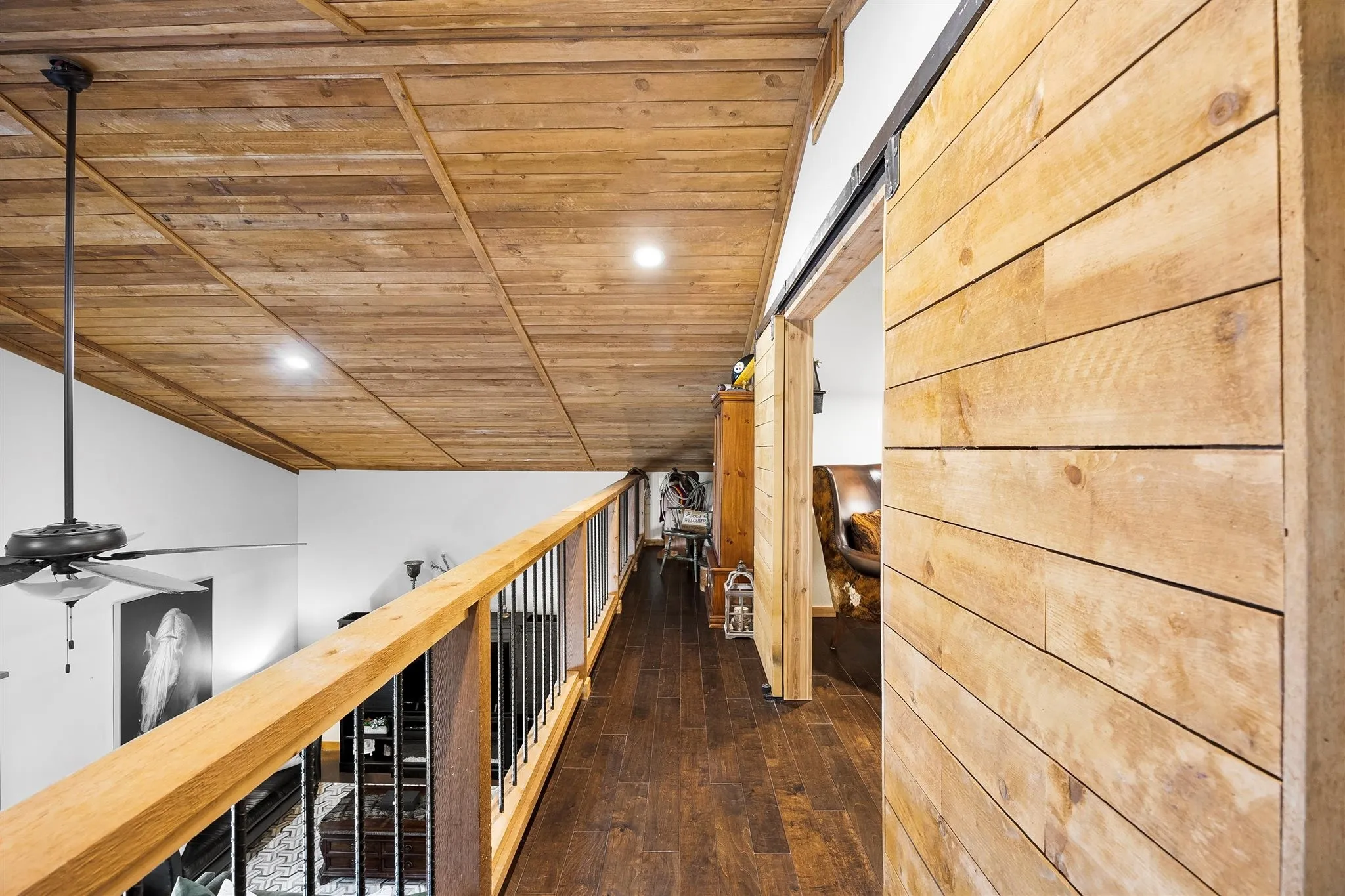 Upper-level hallway with wood-finish flooring, wood plank ceiling, recessed lighting, and a barn door entry