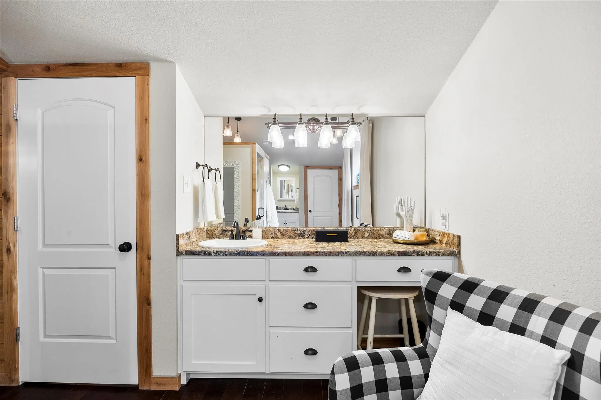 Built-in vanity with white cabinetry, a single basin sink, and a speckled countertop