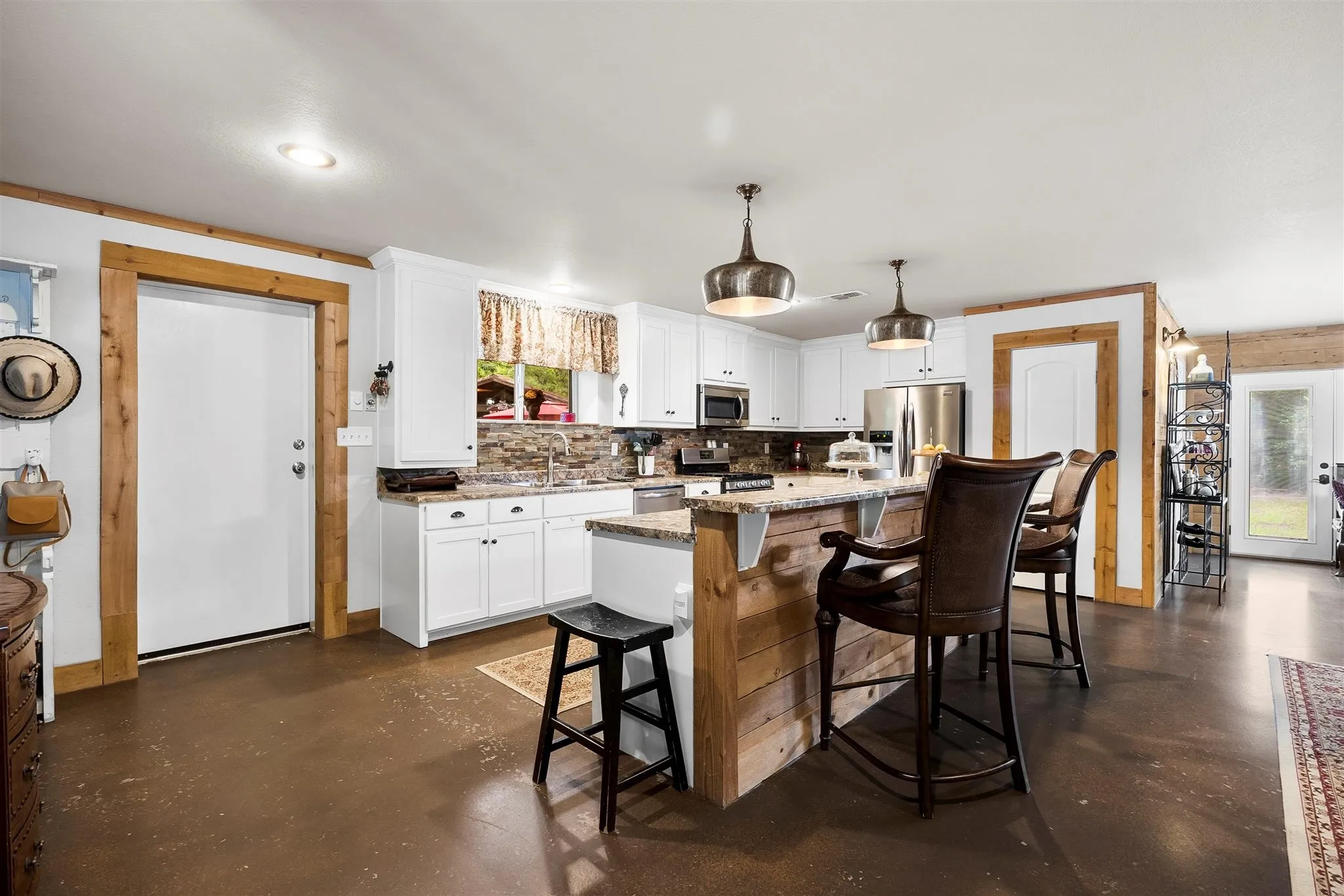 Modern kitchen featuring white cabinetry, granite countertops, and a stone backsplash