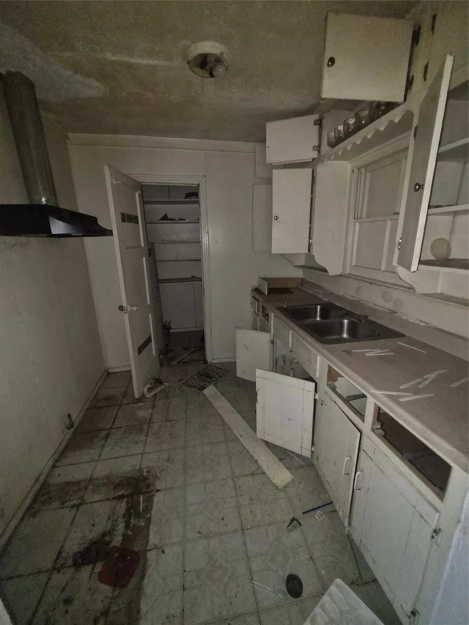 Kitchen space featuring a dual basin sink and white cabinetry