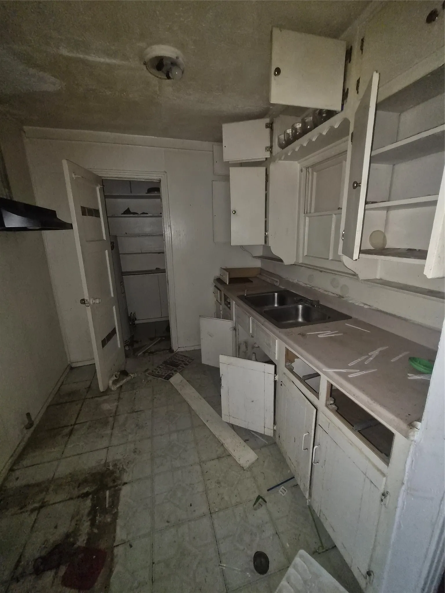 Kitchen featuring a double basin sink, white cabinetry, and tiled flooring
