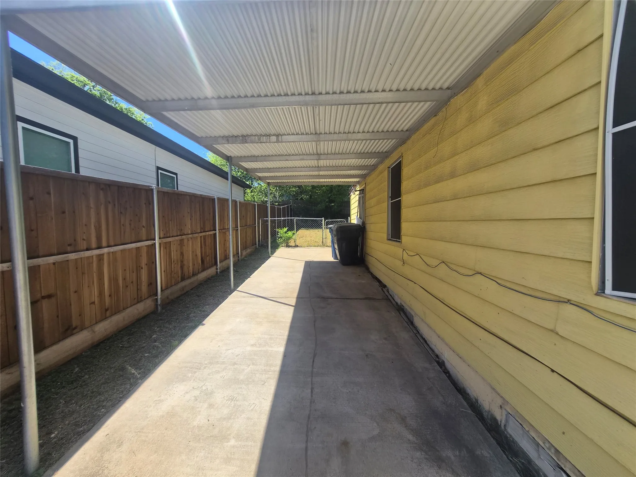 Covered concrete walkway extending alongside the property