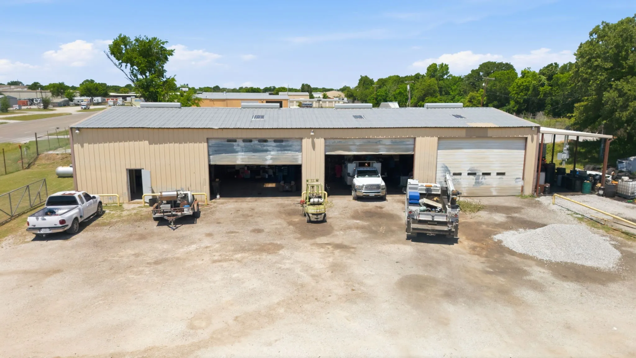 Industrial building featuring a metal roof, two large bay doors, and an additional exterior access door