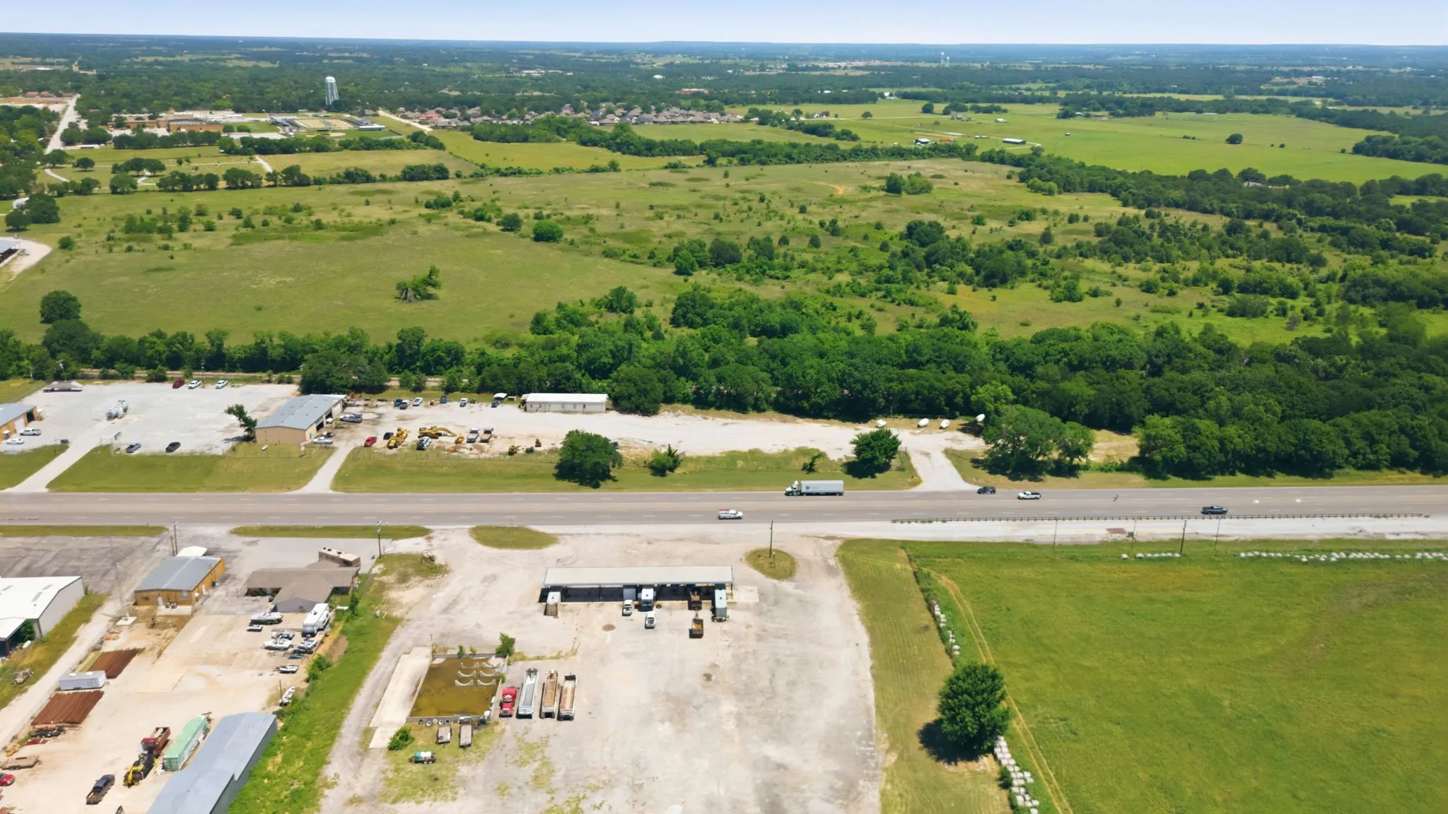 Expansive undeveloped land featuring a combination of open fields and mature tree lines