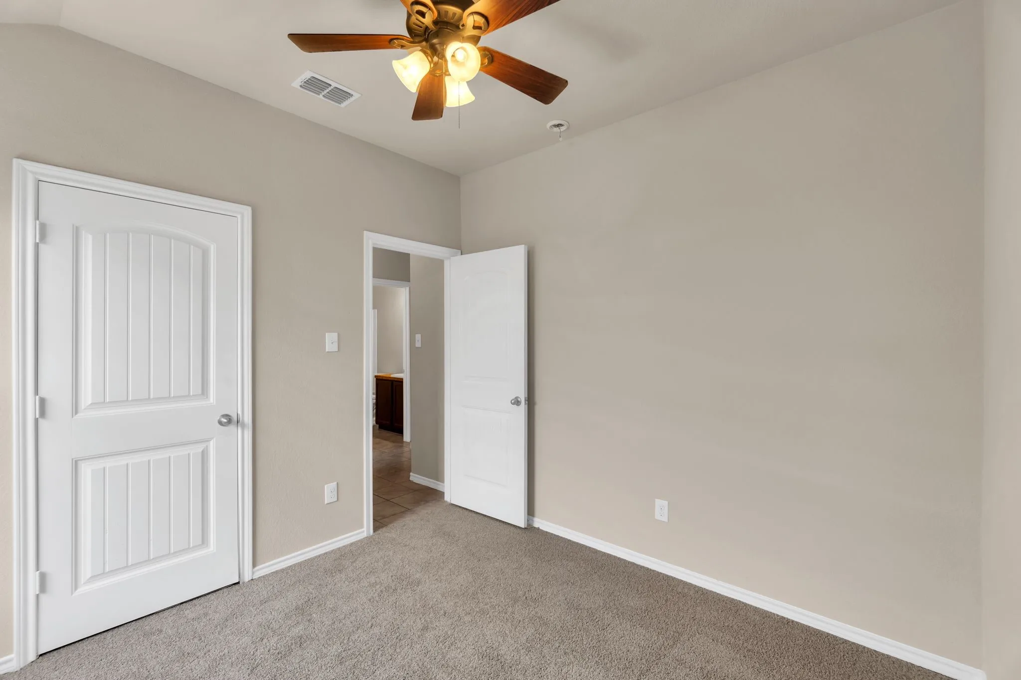 Unfurnished bedroom featuring carpet flooring, lofted ceiling, and ceiling fan