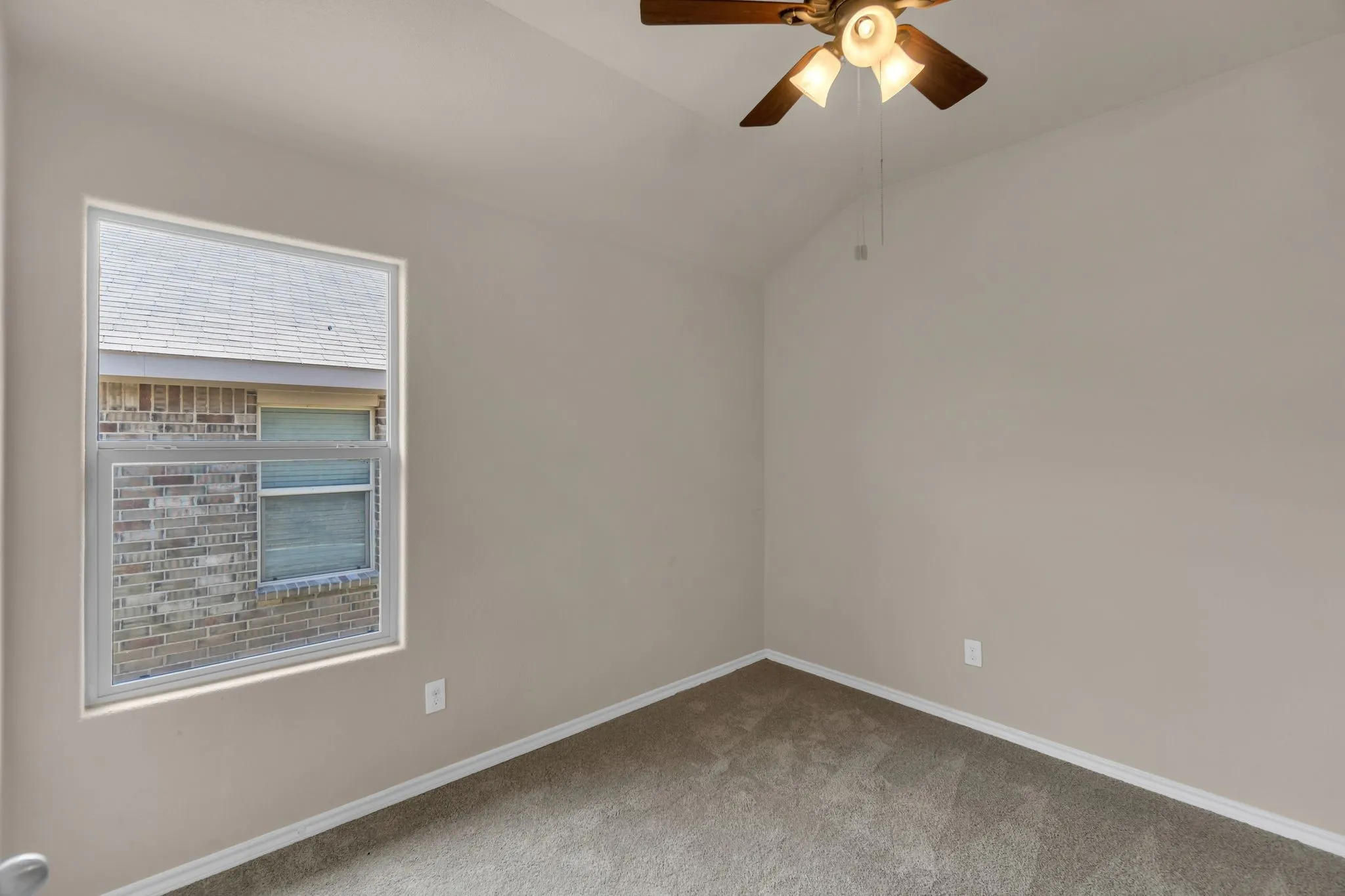 Unfurnished room with ceiling fan, carpet floors, and lofted ceiling