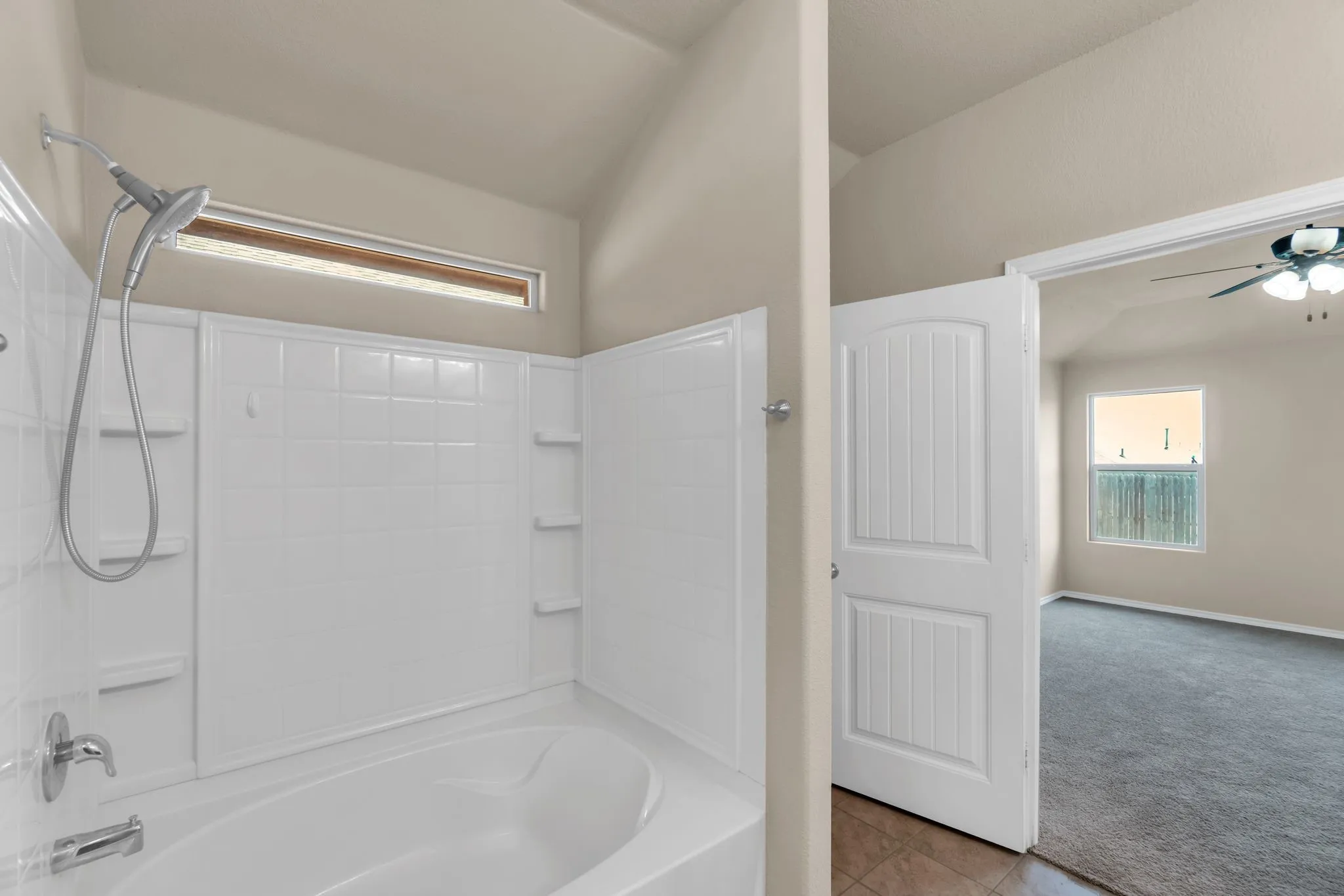 Bathroom with tile flooring, ceiling fan, and shower / bathing tub combination