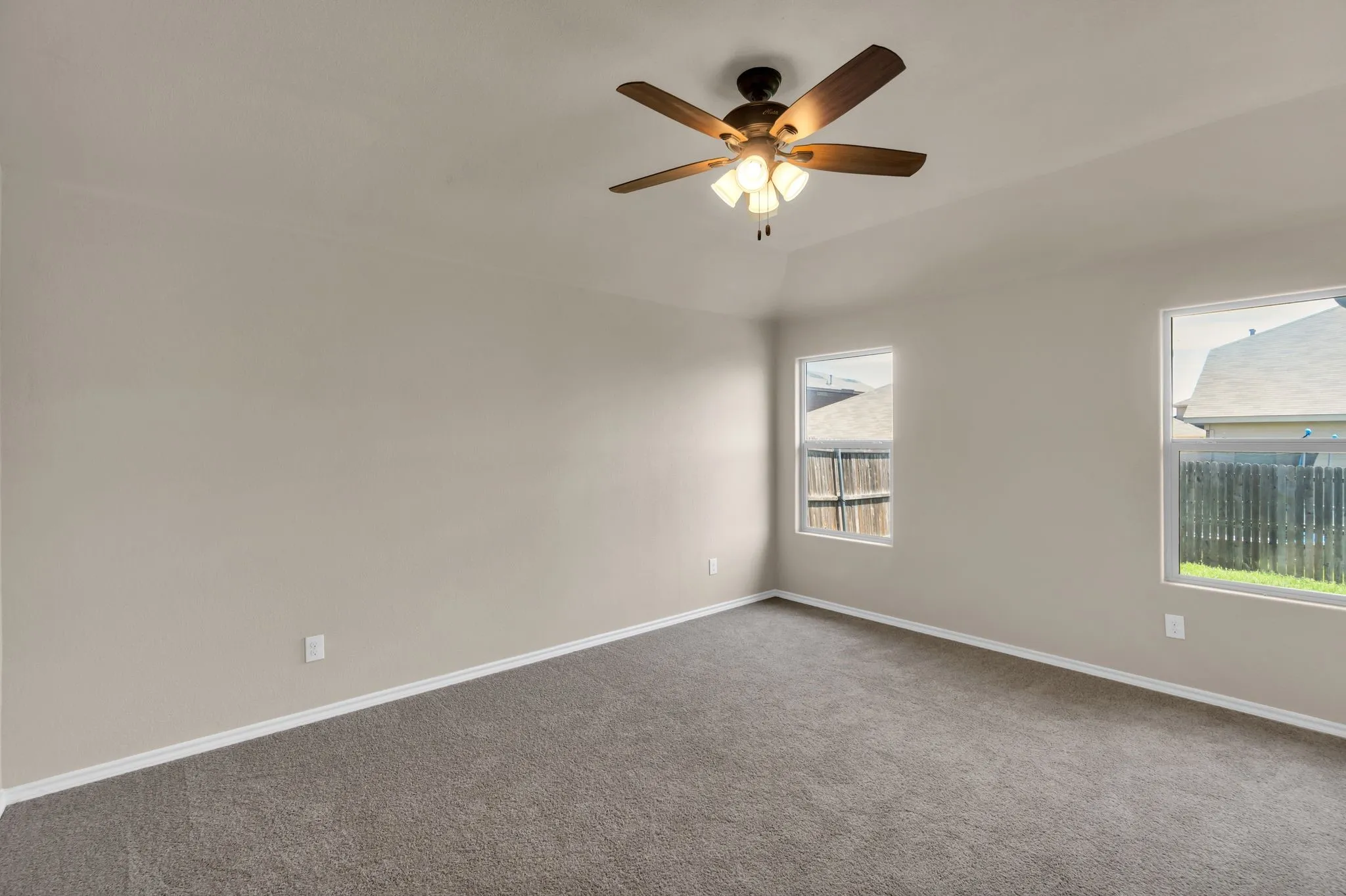 Empty room with ceiling fan and carpet floors