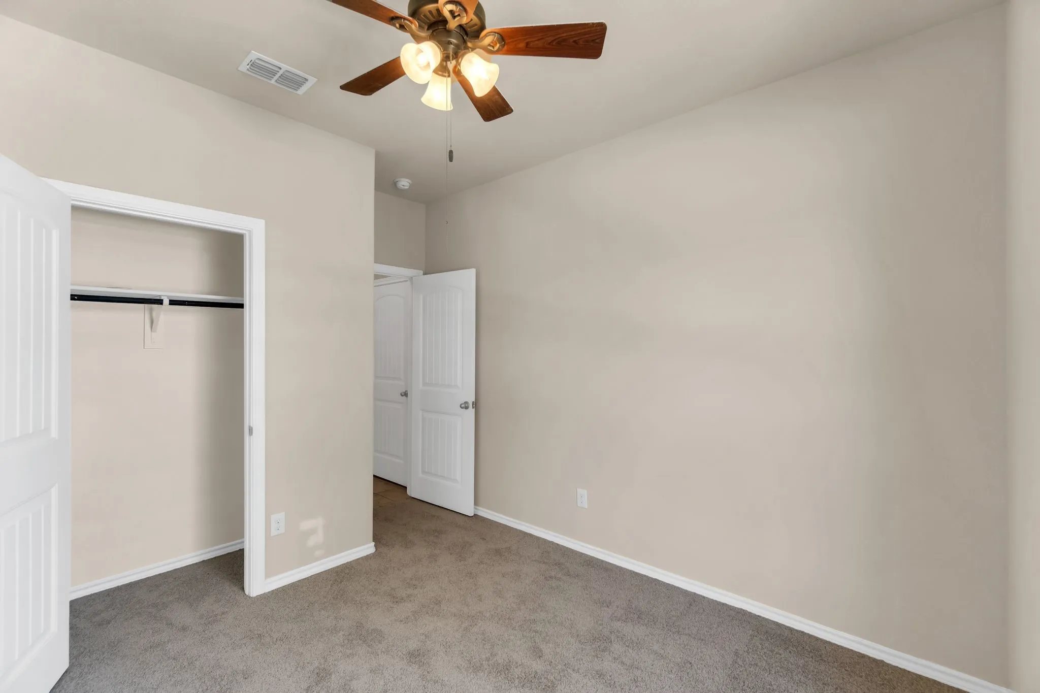 Unfurnished bedroom featuring carpet flooring, a closet, and ceiling fan