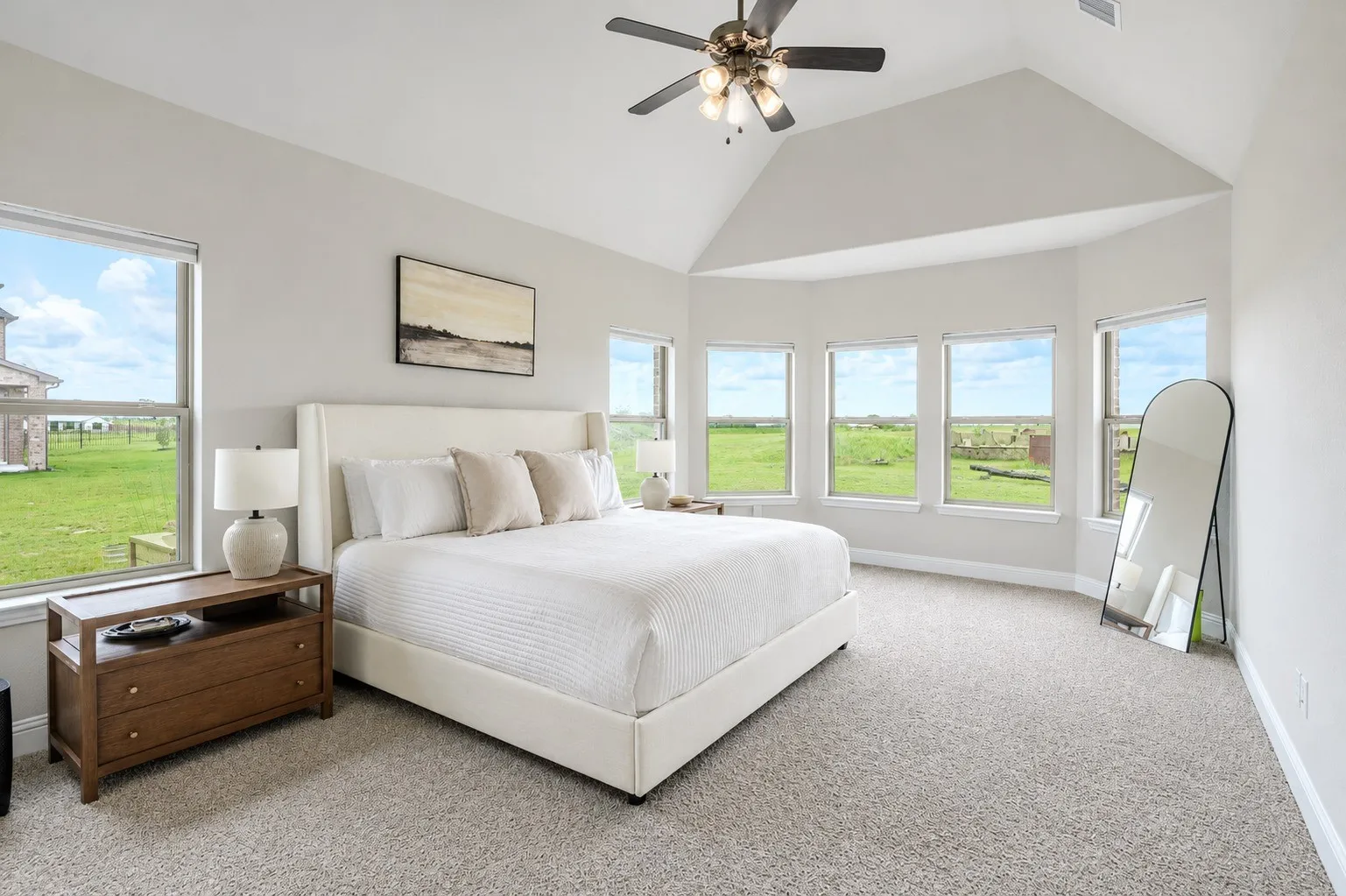 Light gray walls complement the vaulted ceiling and neutral carpeting