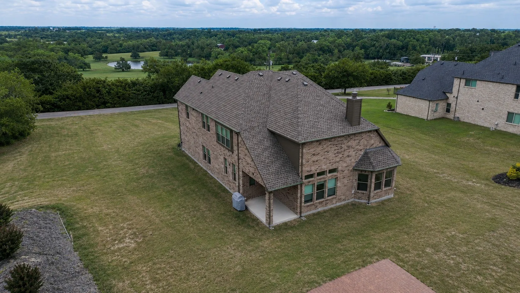 Brick exterior with a multi-gabled roofline and an integrated covered patio