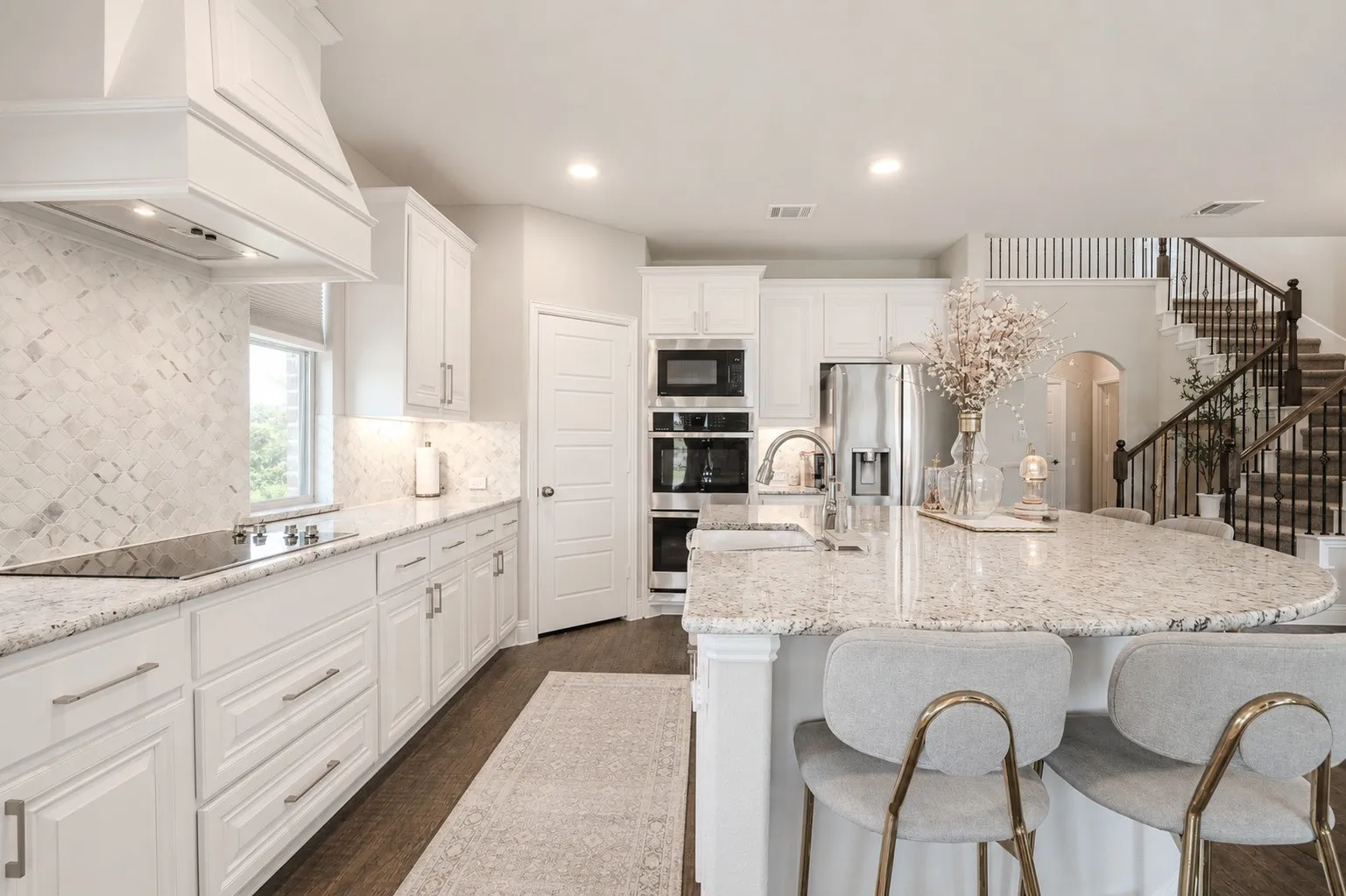 Contemporary kitchen featuring white cabinetry, light-toned countertops, and a white tile backsplash