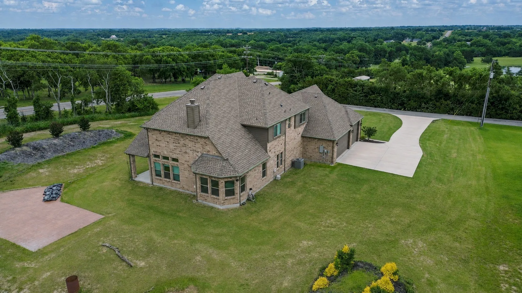 Expansive property featuring a brick-clad residence with a multi-level roofline