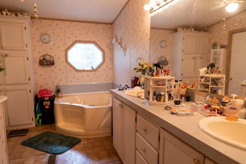 Bathroom featuring a built-in corner soaking tub with an octagonal window overhead