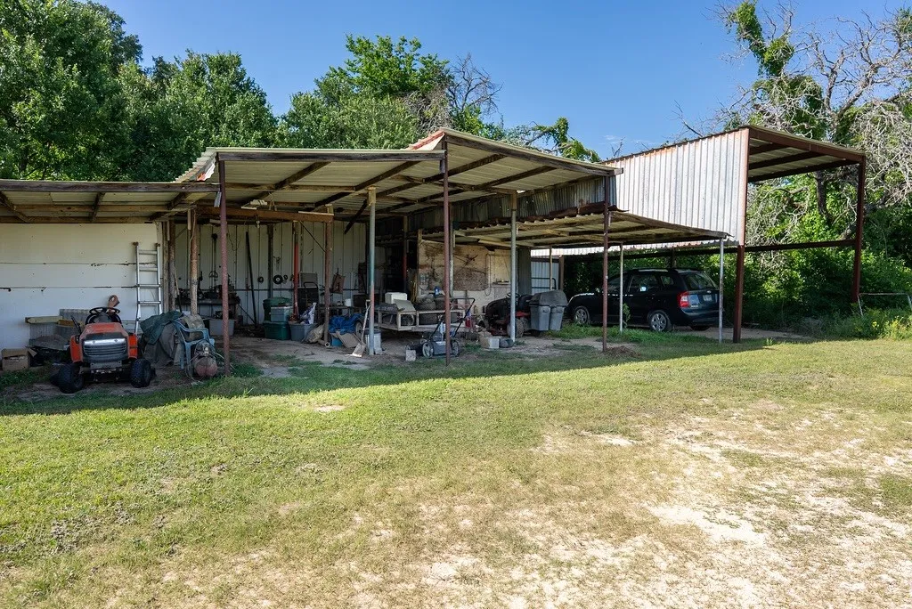Expansive metal-framed outbuilding with multiple covered sections, providing ample sheltered space for RV